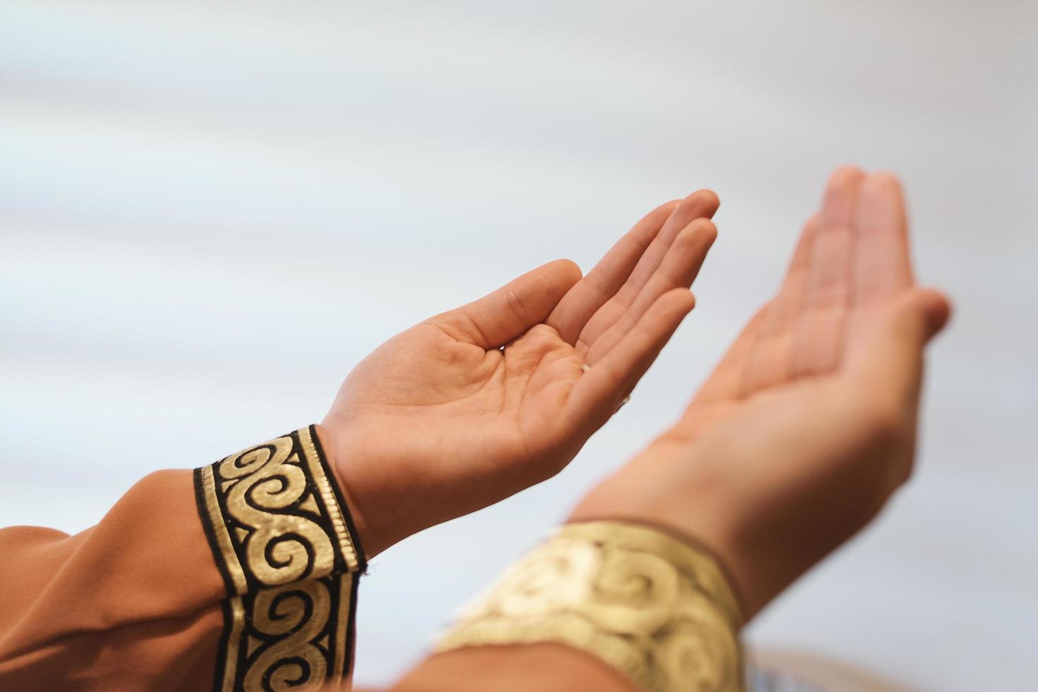 Hands of a Muslim or Islamic woman gesturing while praying at home photo