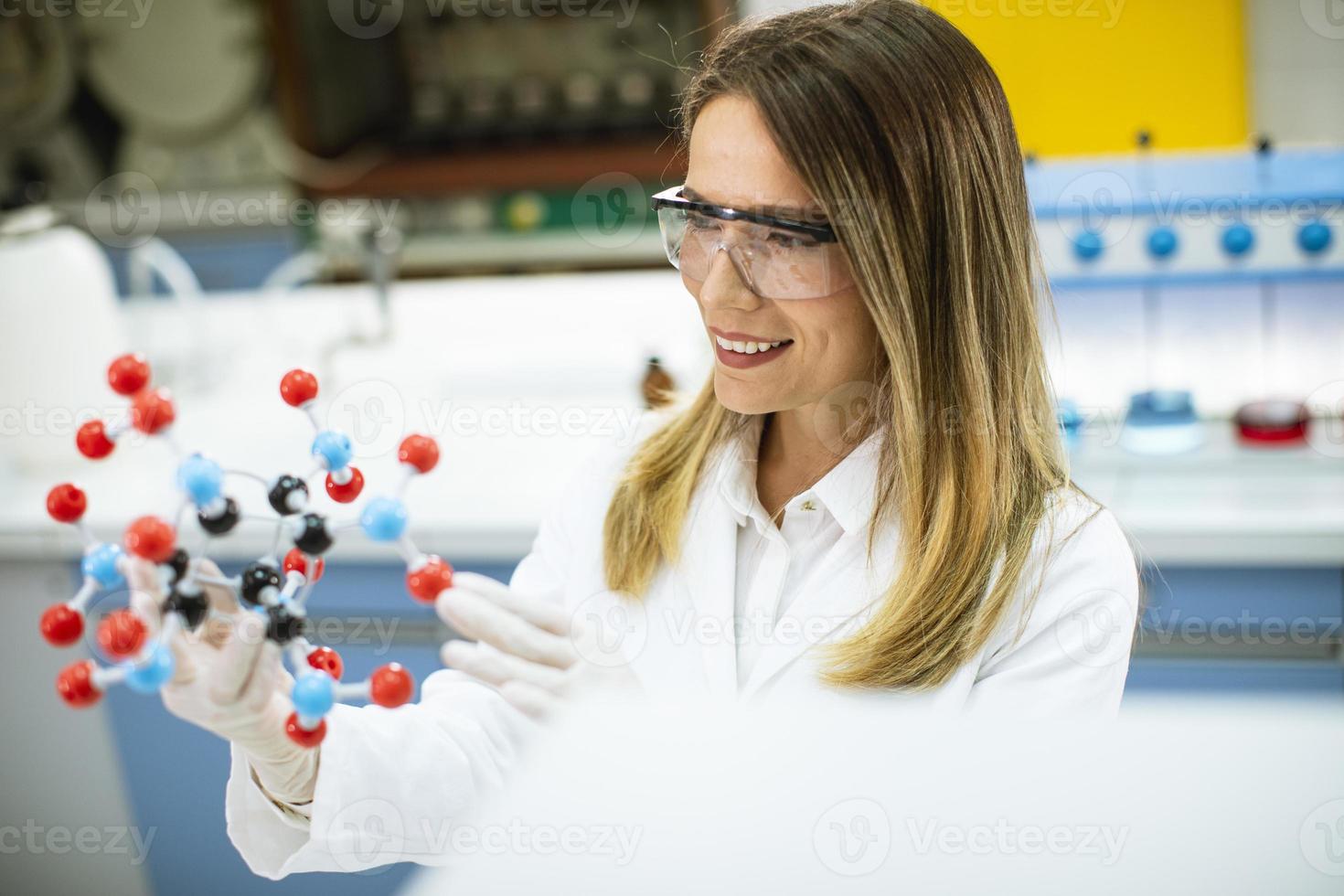 Female chemist hold molecular model in the lab photo
