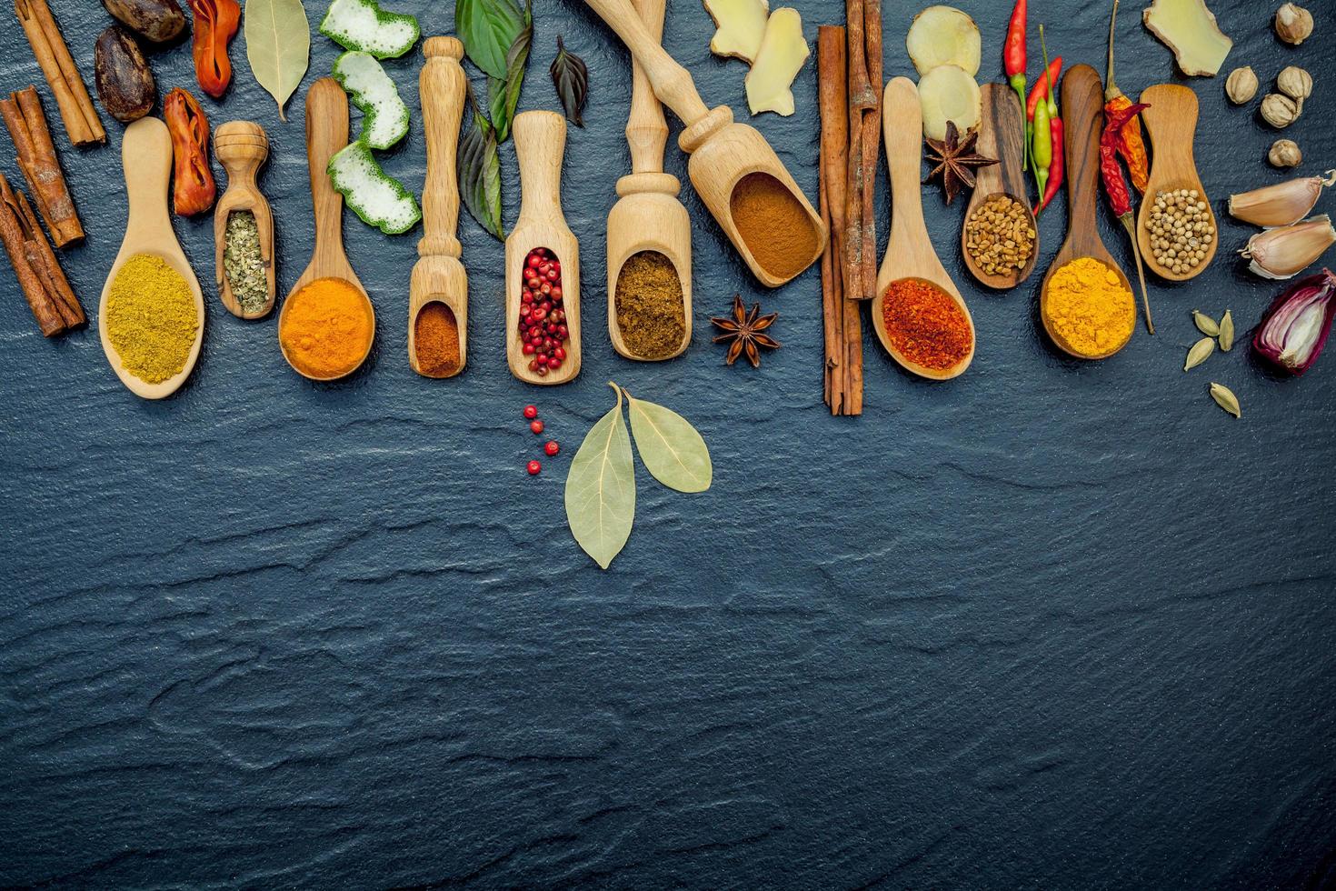 Assortment of herbs and spices on dark slate photo