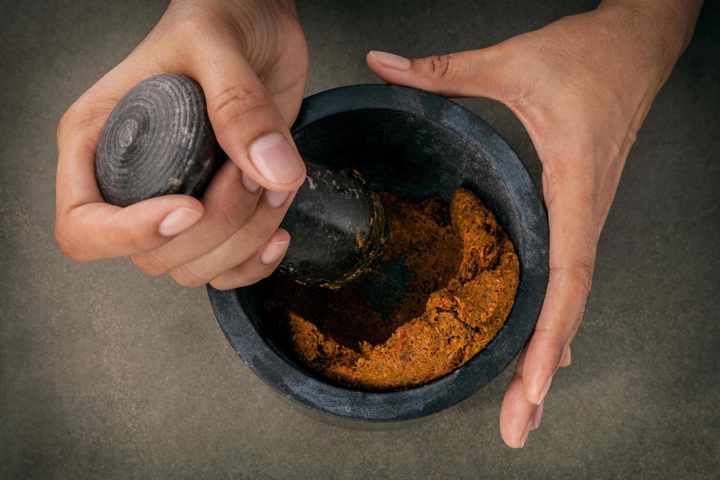 Close-up of hands using a mortar photo