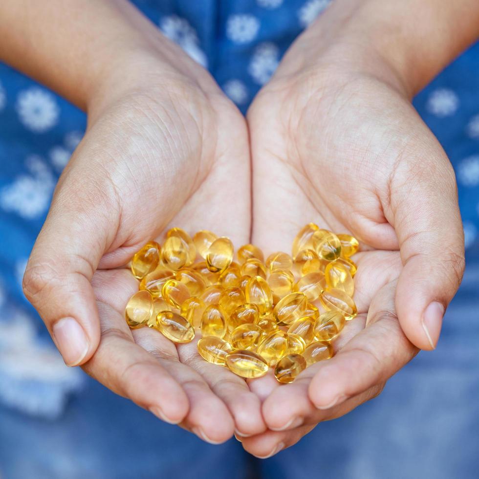 Fish oil pills in hands photo