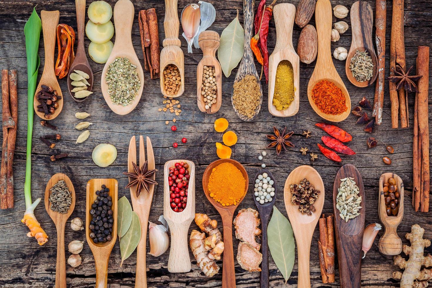 Flat lay of herbs and spices with spoons photo