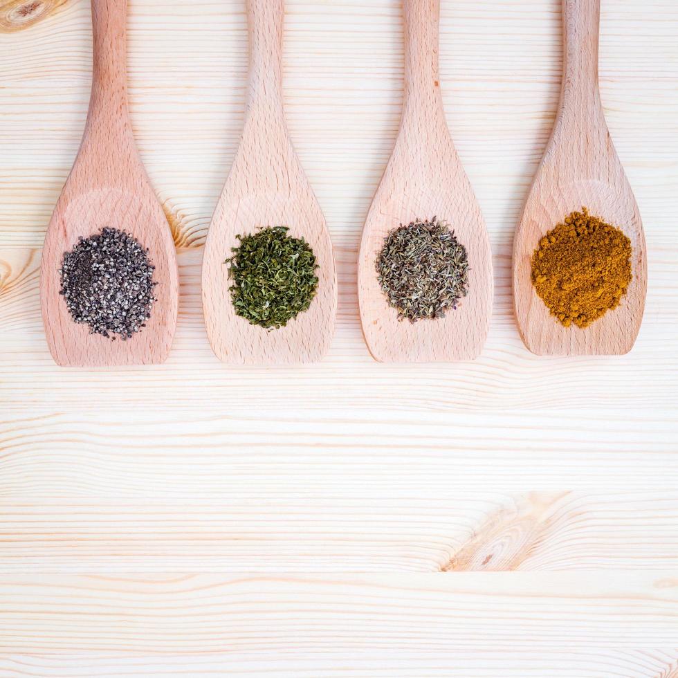 Dried herbs and spices in spoons photo