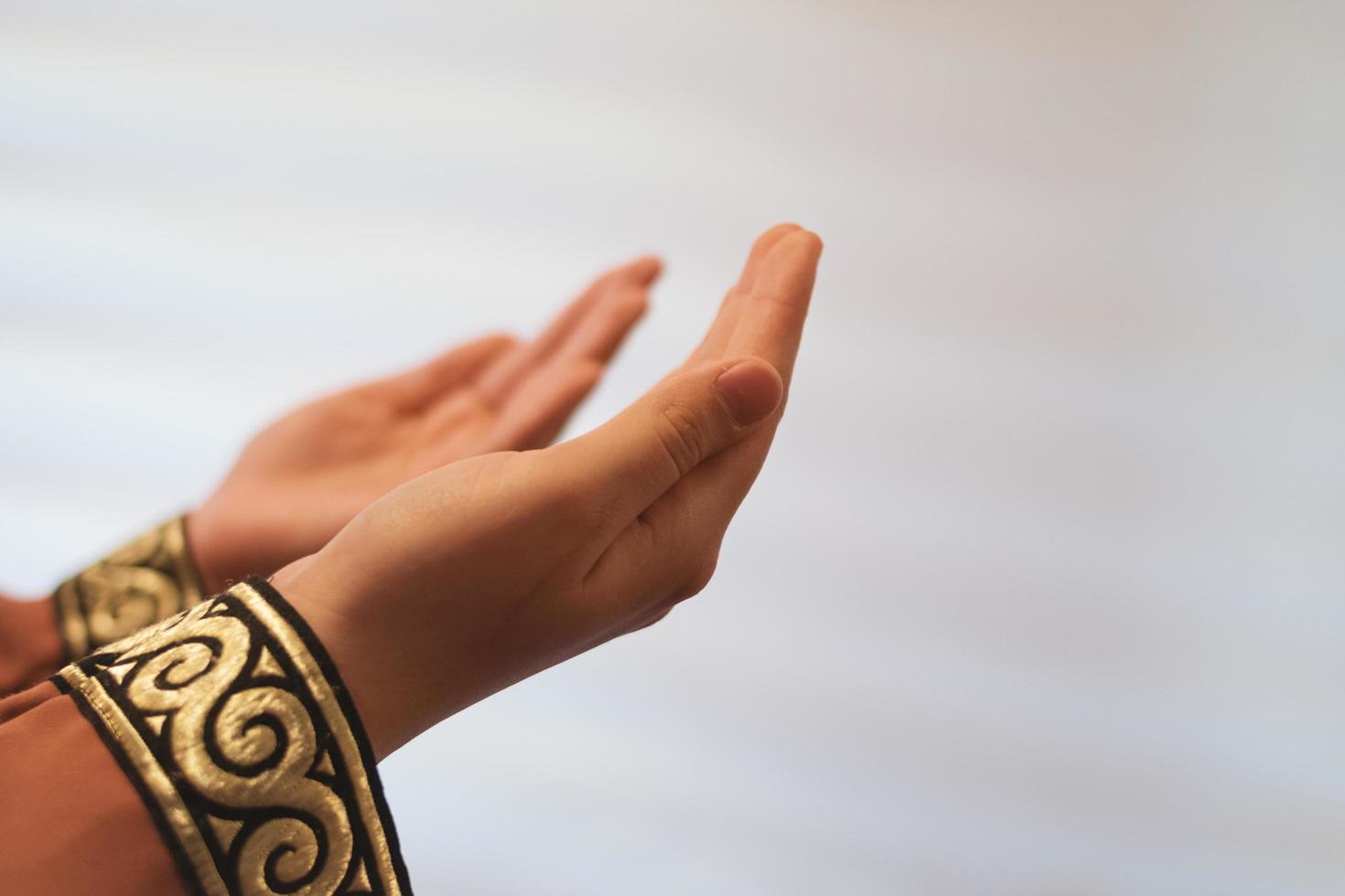 Hands of a Muslim or Islamic woman gesturing while praying at home photo