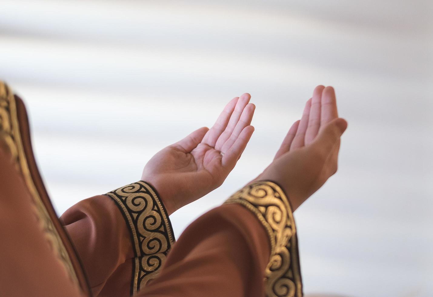 Hands of a Muslim or Islamic woman gesturing while praying at home photo