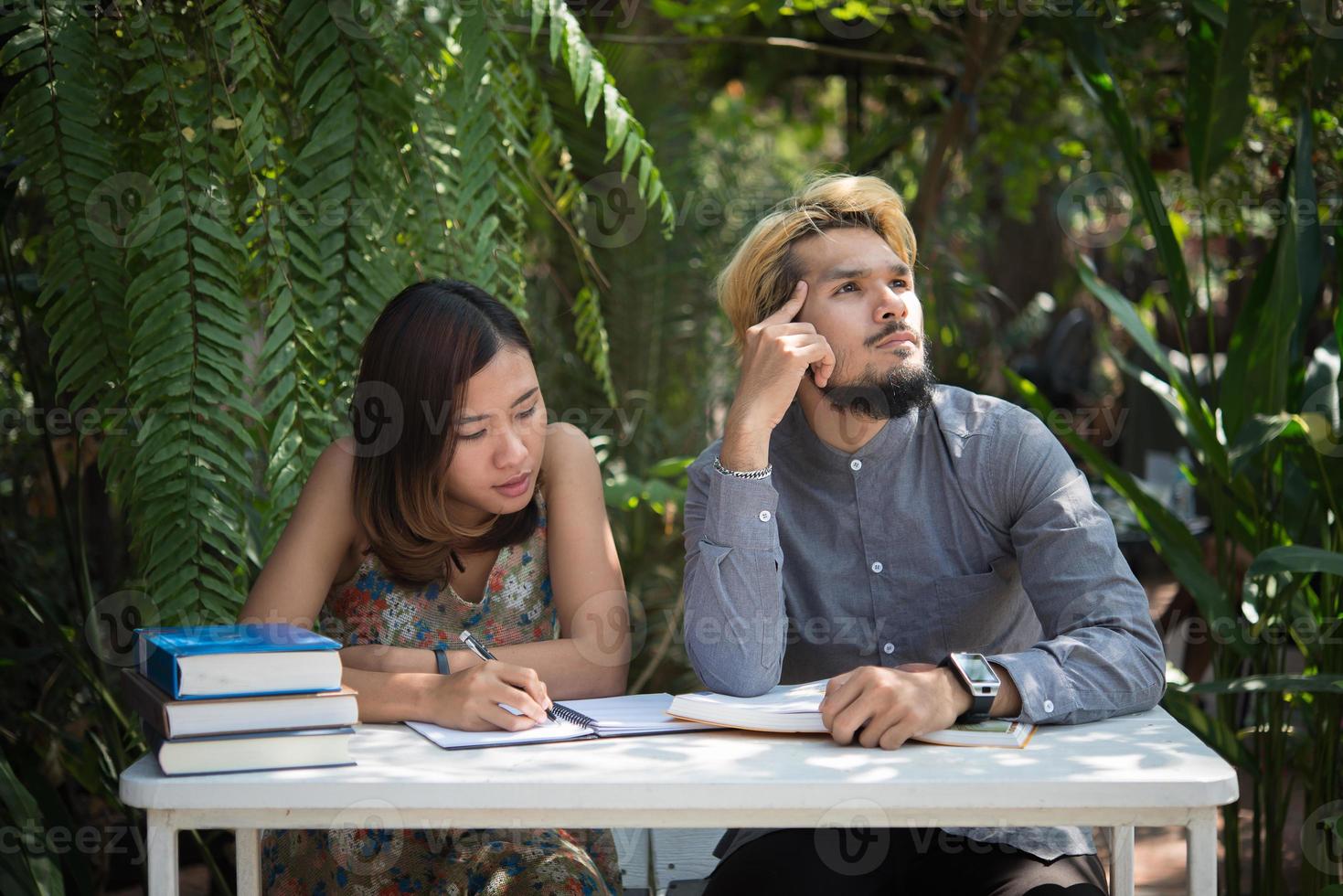 Education couple sitting at nature home garden reading for exam together photo