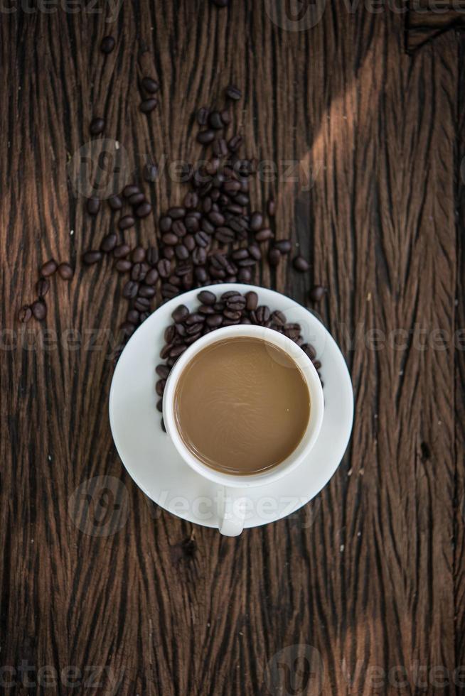 Vista superior de la taza de café y granos de café en la mesa de madera foto