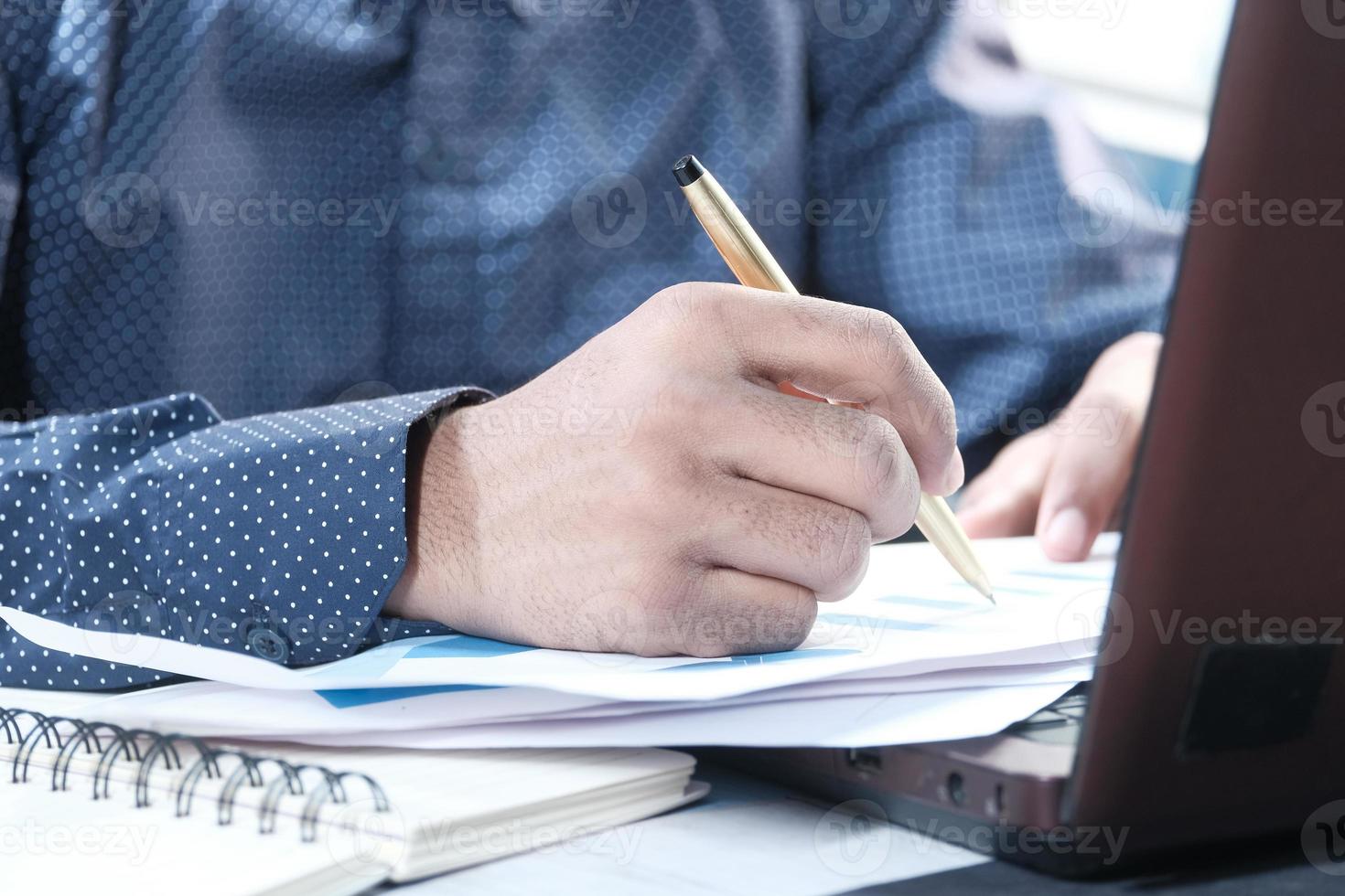 La mano del hombre escribiendo en el escritorio foto