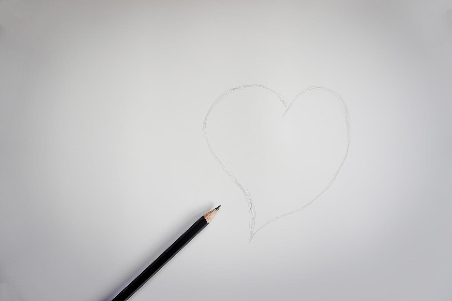 A sketch of a handwritten heart from a pencil on a white paper background photo