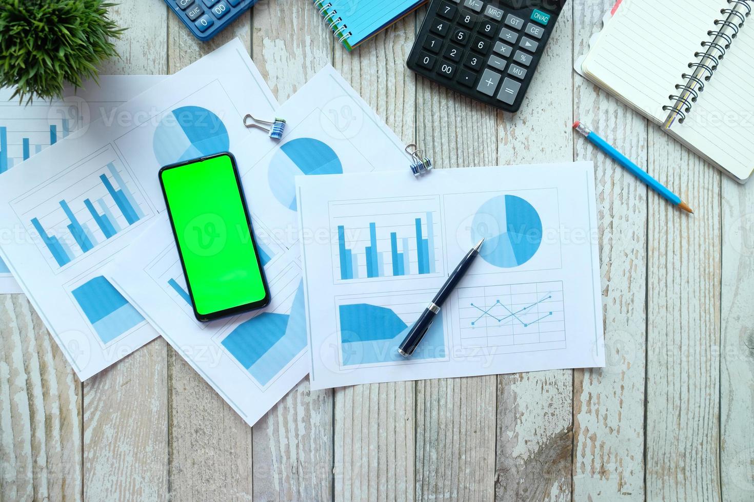 Smart phone, calculator, and notepad on table photo