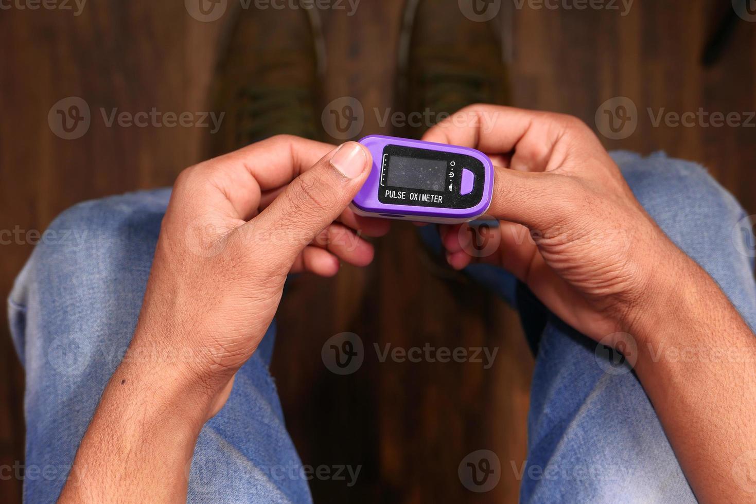 Man using pulse oximeter photo