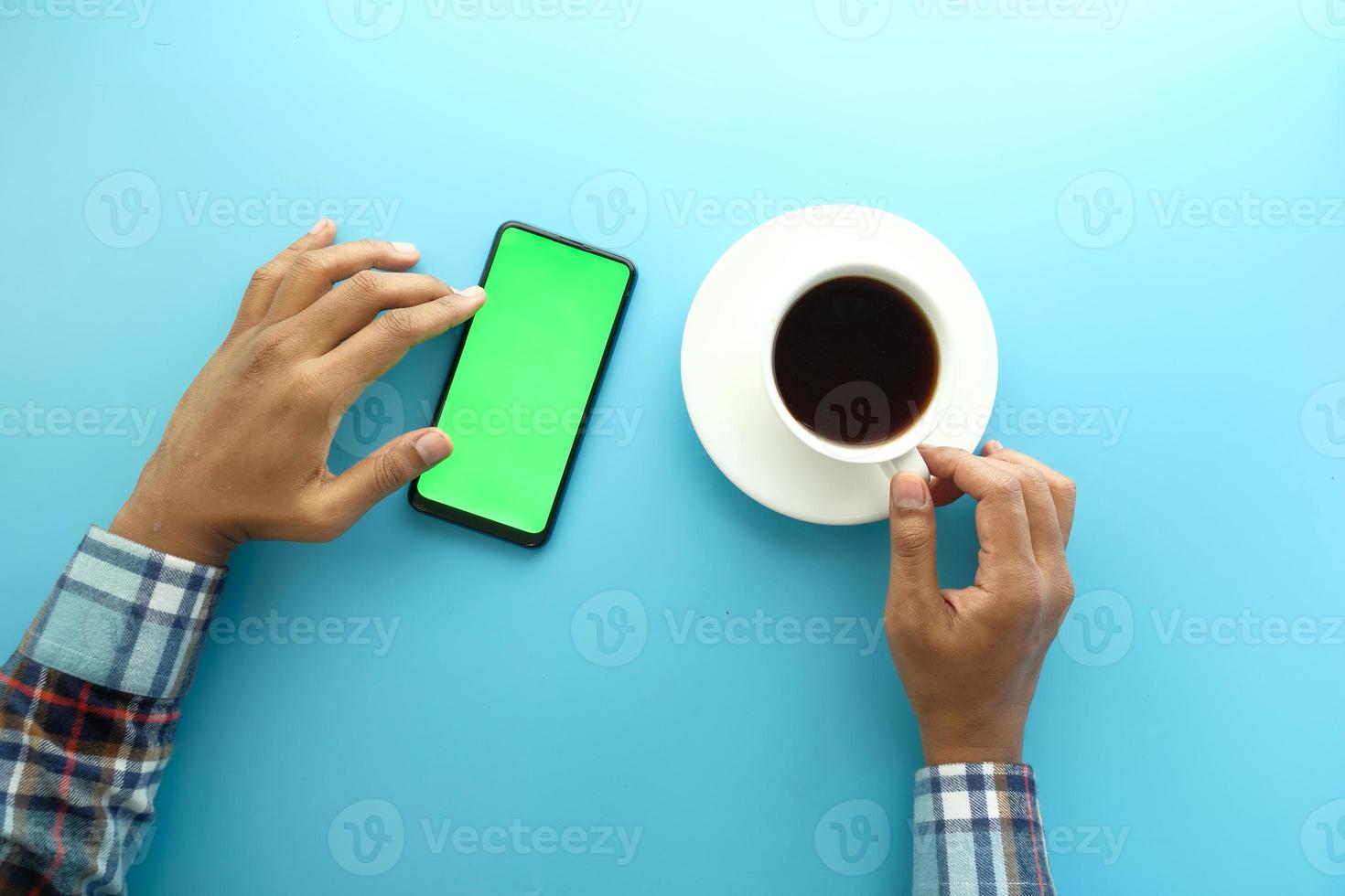 Top view of man using a smart phone and drinking coffee photo