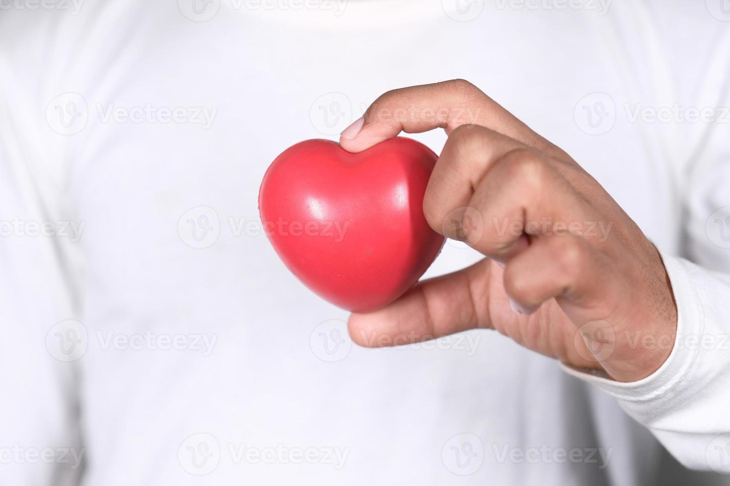 hombre sosteniendo un pequeño corazón rojo foto