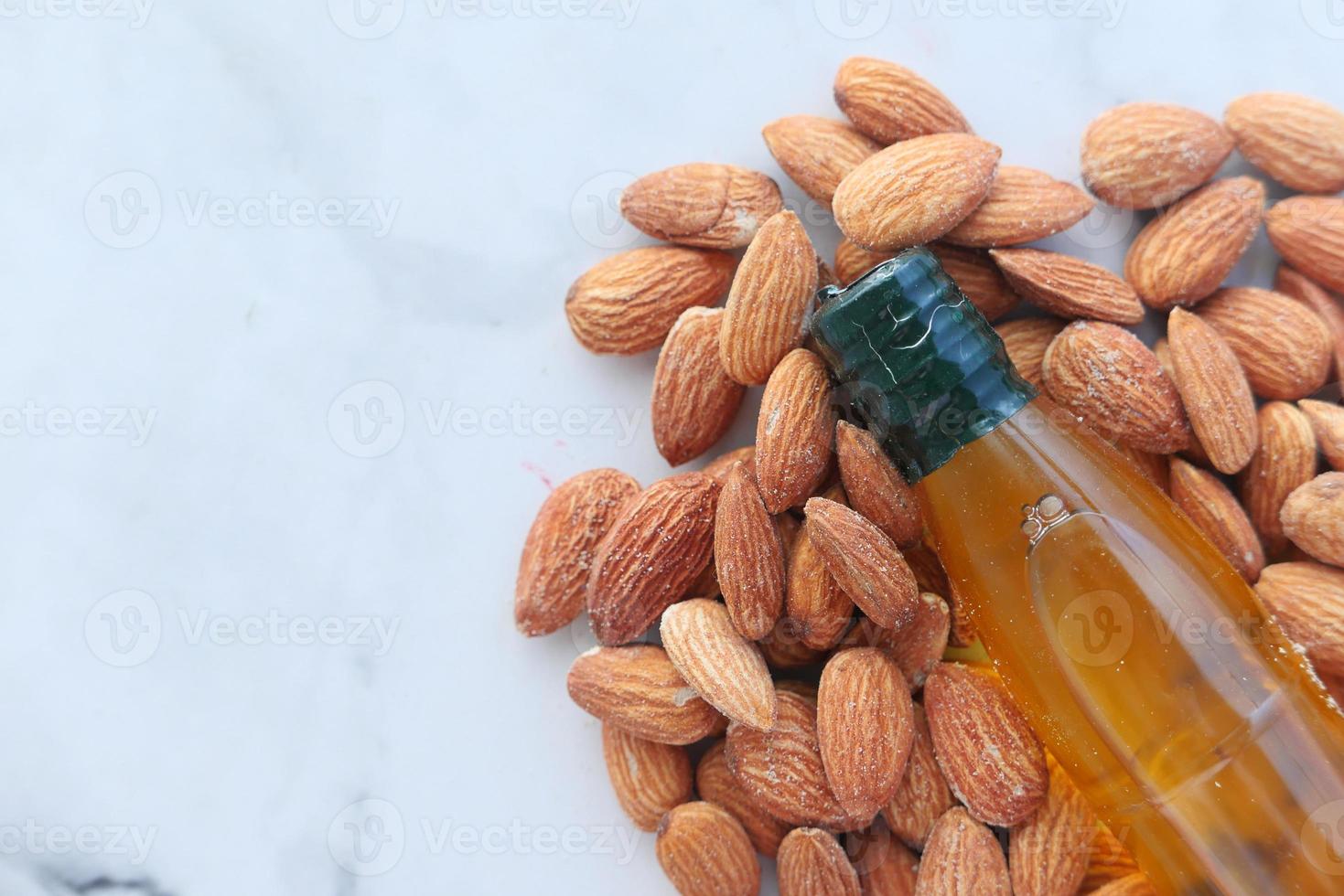 Almond oil in bottle on wooden background photo