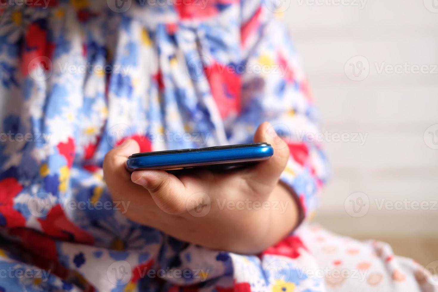 niño sosteniendo teléfono inteligente foto