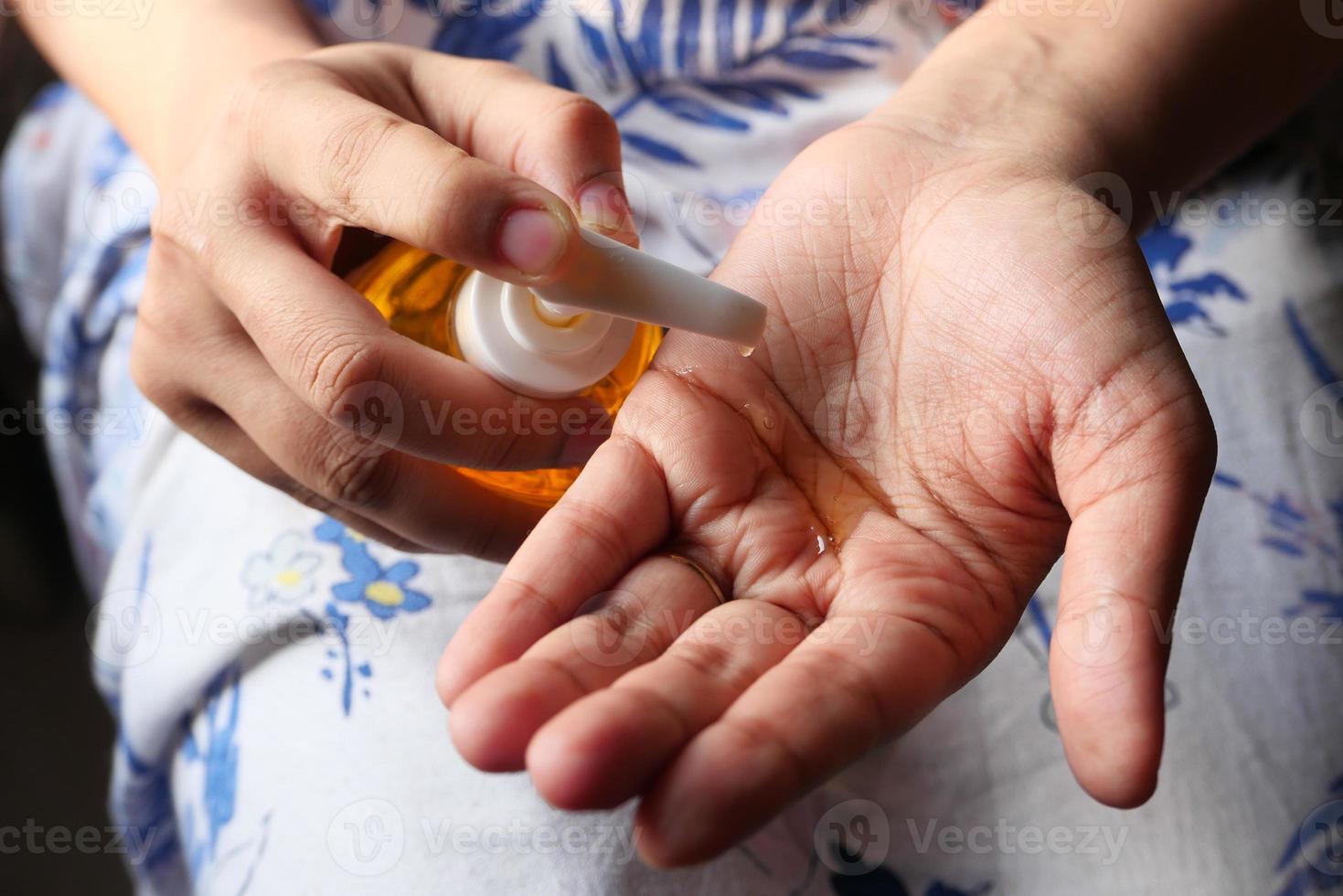 Young woman using hand sanitizer with copy space photo