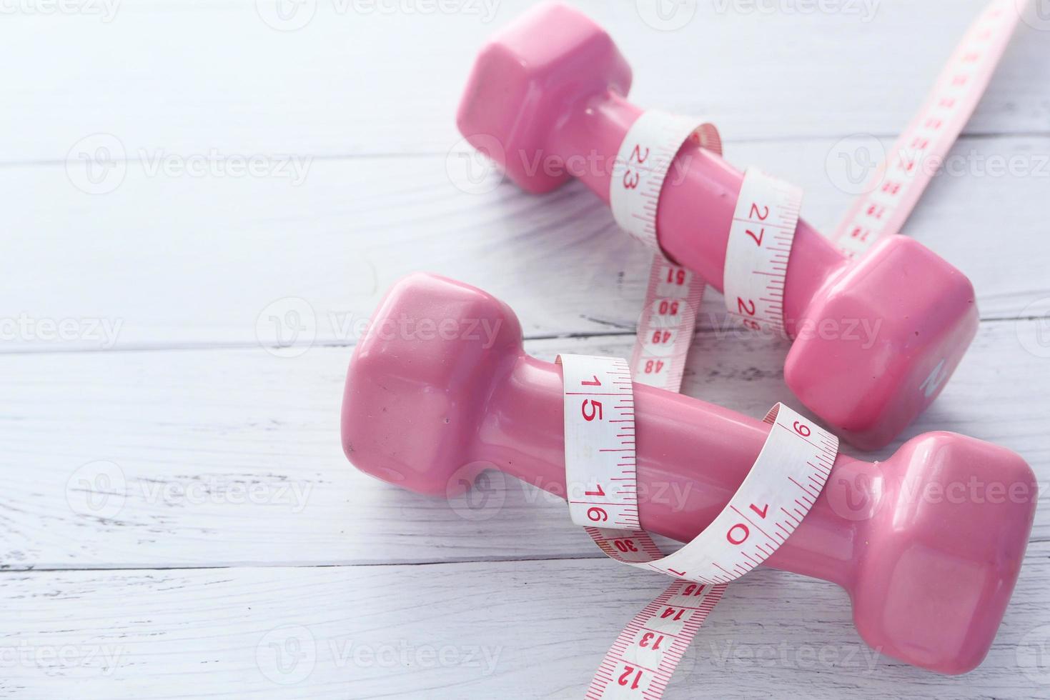 Pink weights with tape measure around them photo