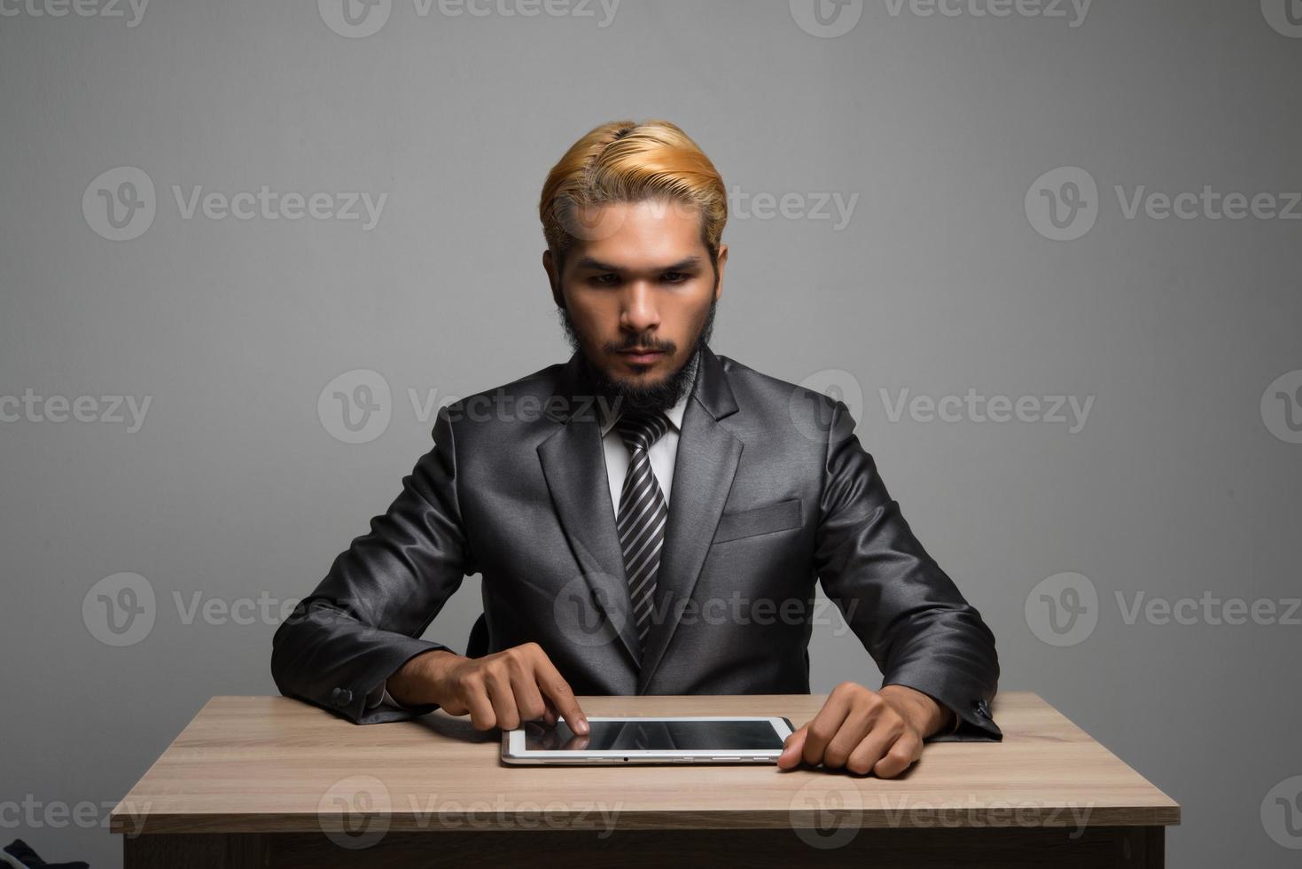 Businessman touching on digital tablet and looking on a blank screen photo