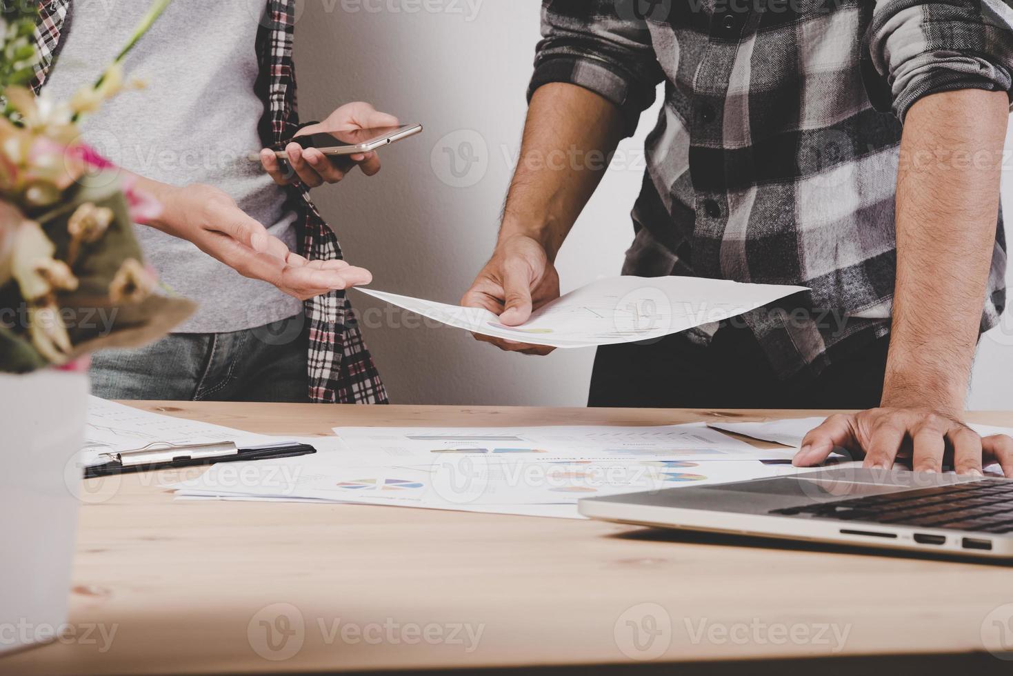 Close-up de gente de negocios que trabaja con diagramas de estrategia en un escritorio de madera en la oficina foto