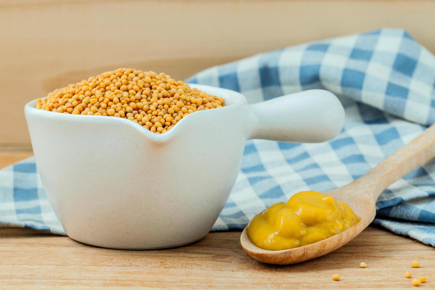 Mustard seeds and mustard on a table photo