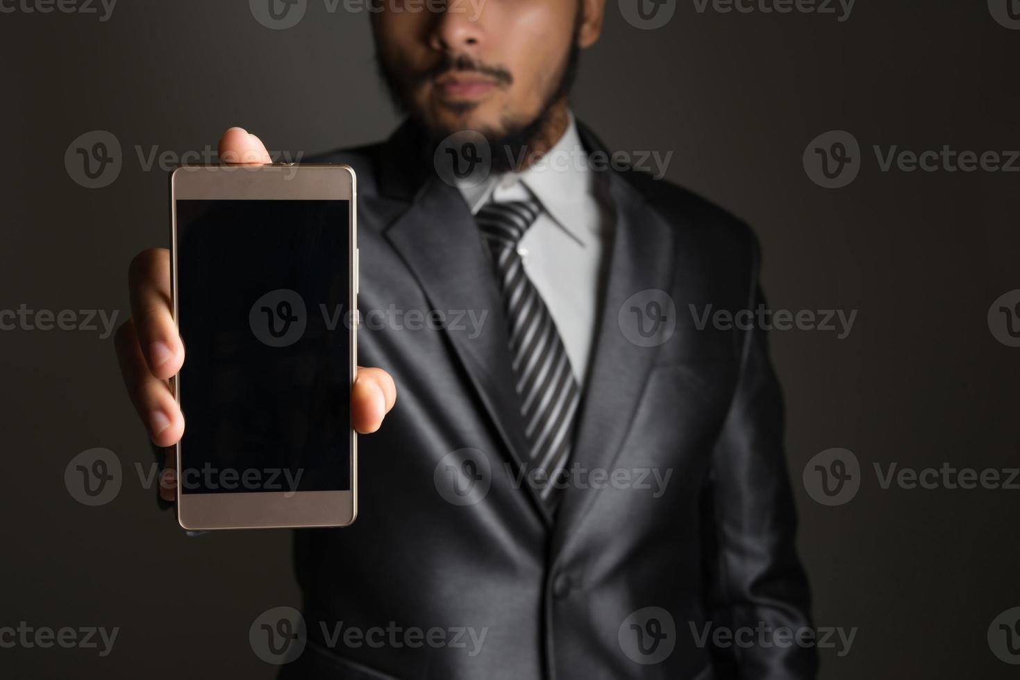 retrato, de, hombre de negocios, actuación, smartphone, contra, fondo negro foto
