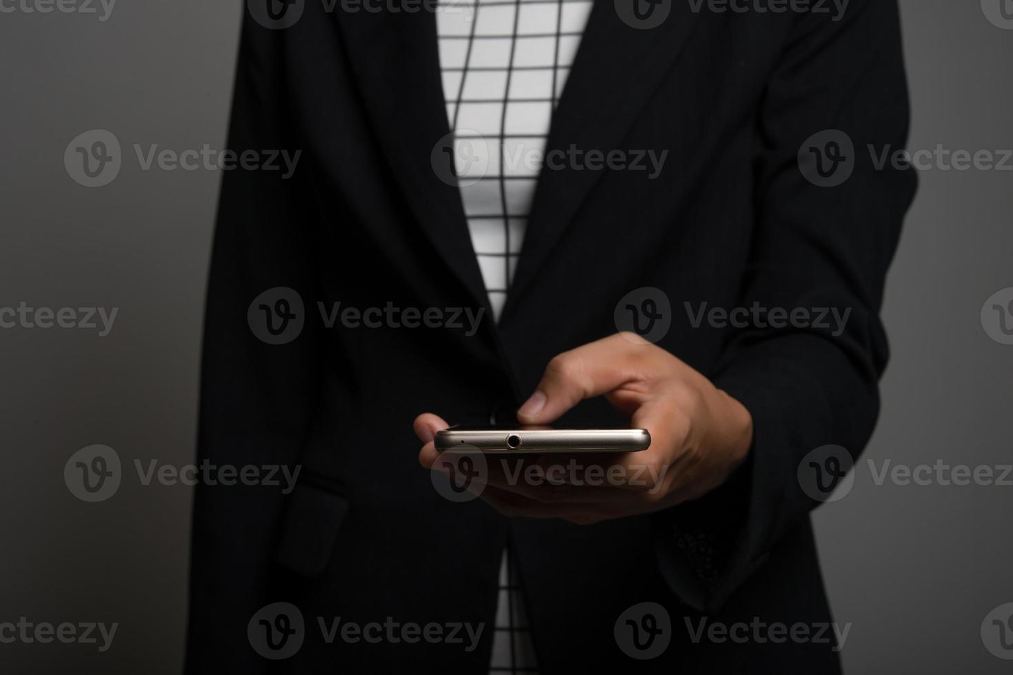 Mujer de negocios joven con teléfono móvil aislado sobre fondo negro foto