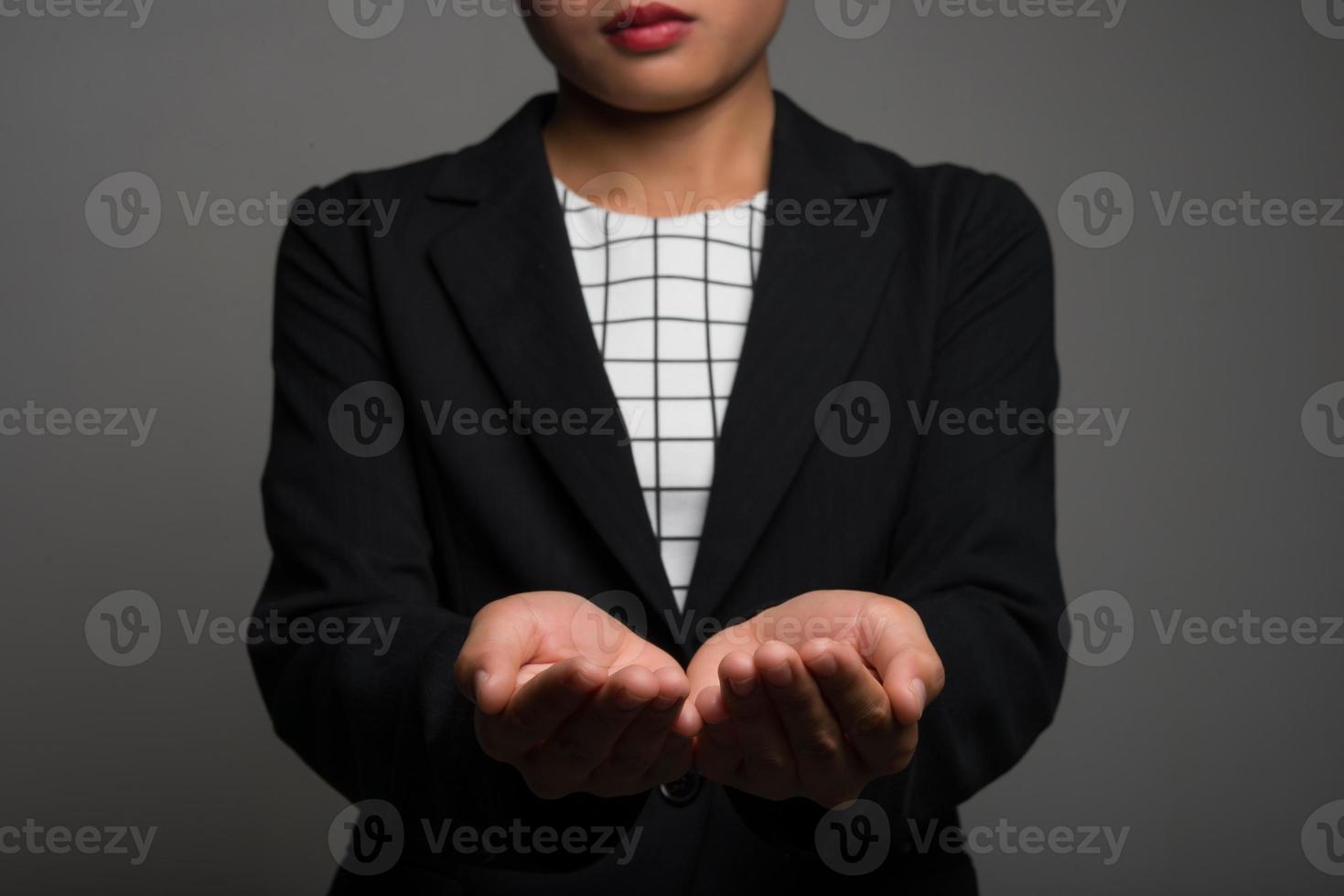 Young business woman presenting a copyspace isolated on black background photo