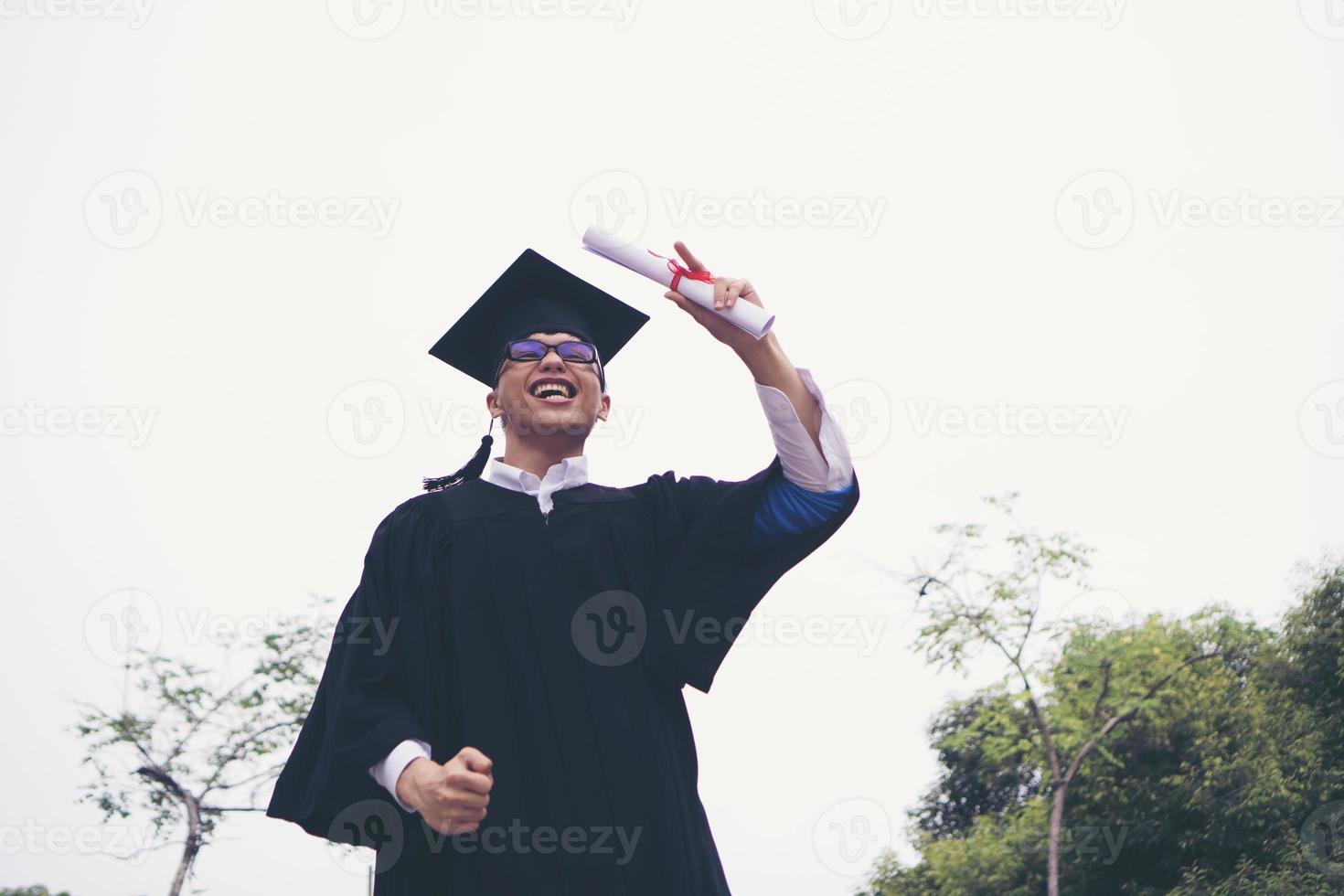Happy graduate student holding a diploma in hand photo