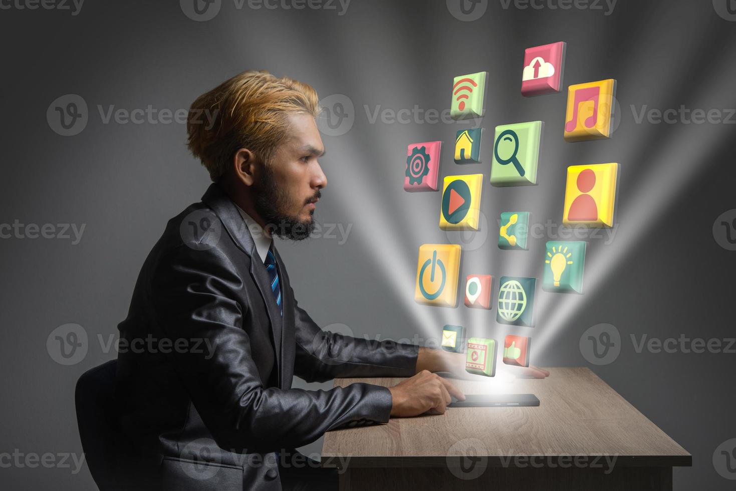 Young businessman in office with modern digital media 3D icons photo