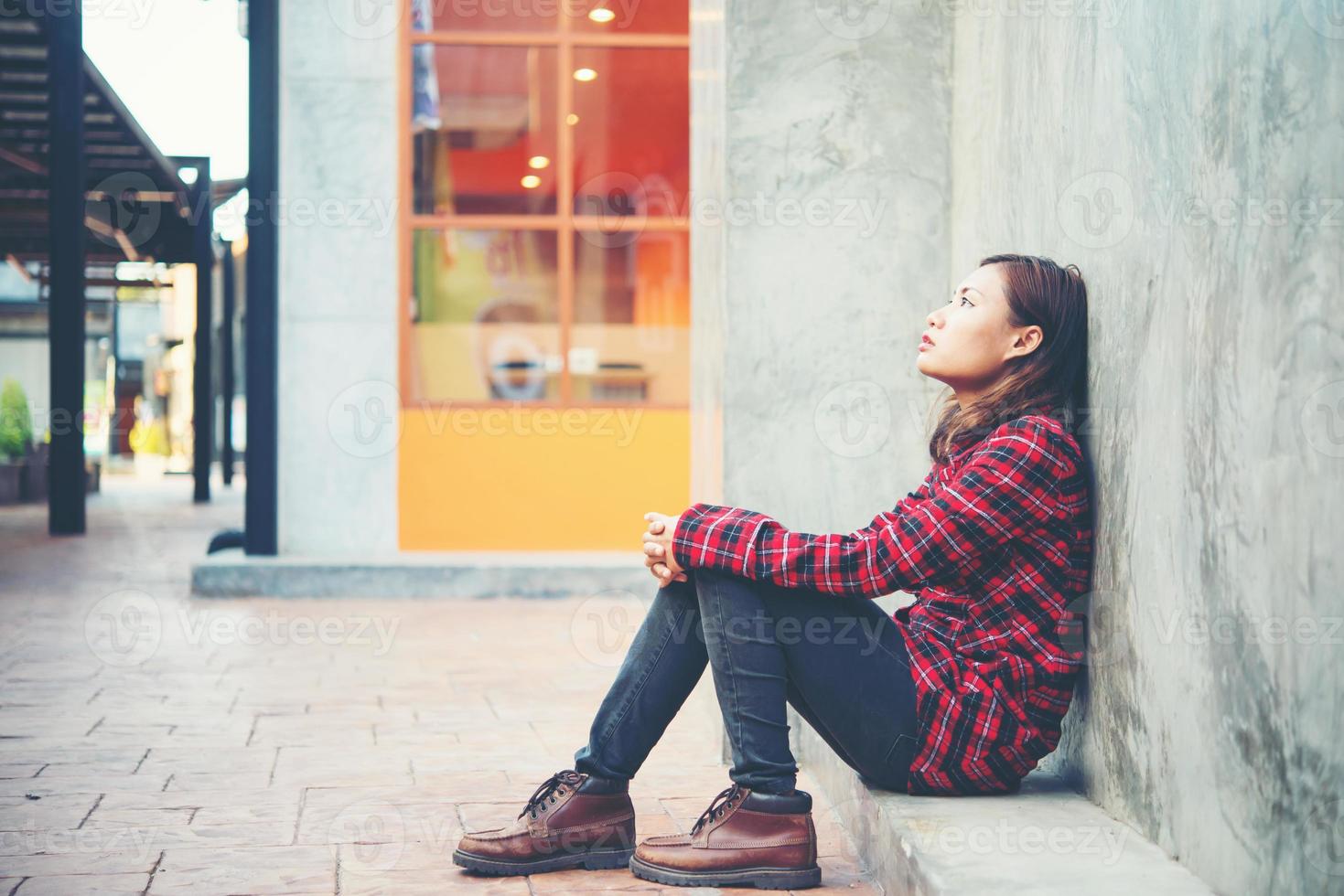 Upset woman sitting on the floor against grunge background photo