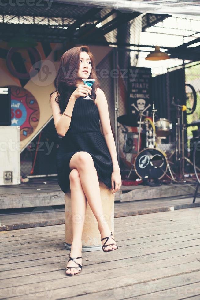 Portrait of a happy young woman having fun and drinking a cocktail photo