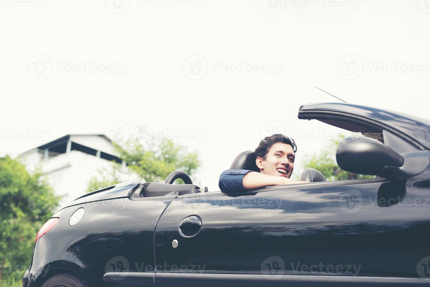 apuesto joven en coche deportivo vistiendo un traje foto