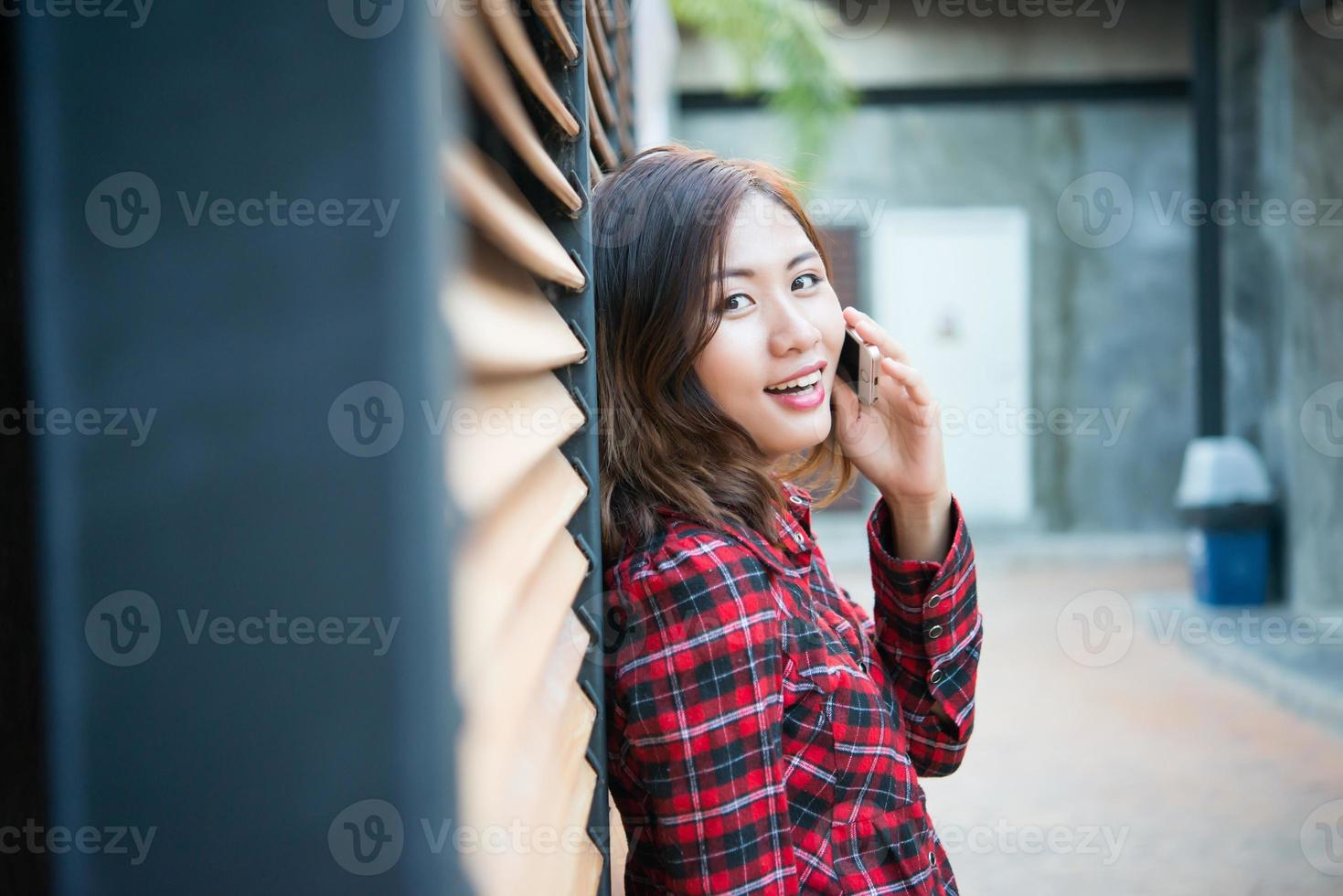Beautiful young hipster standing talking on smartphone isolated with grunge background photo