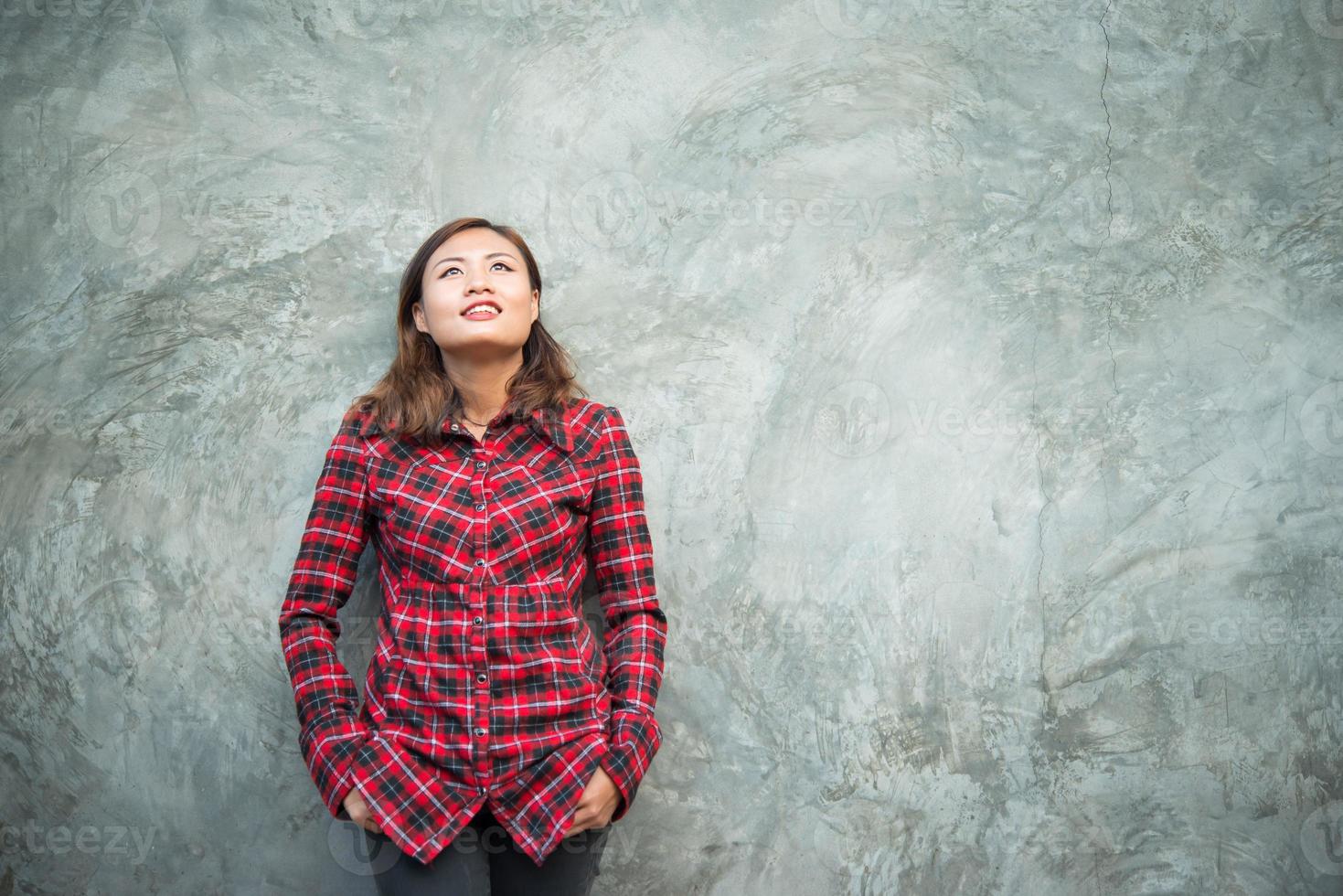 Beautiful young hipster standing in trendy clothes on grunge background photo