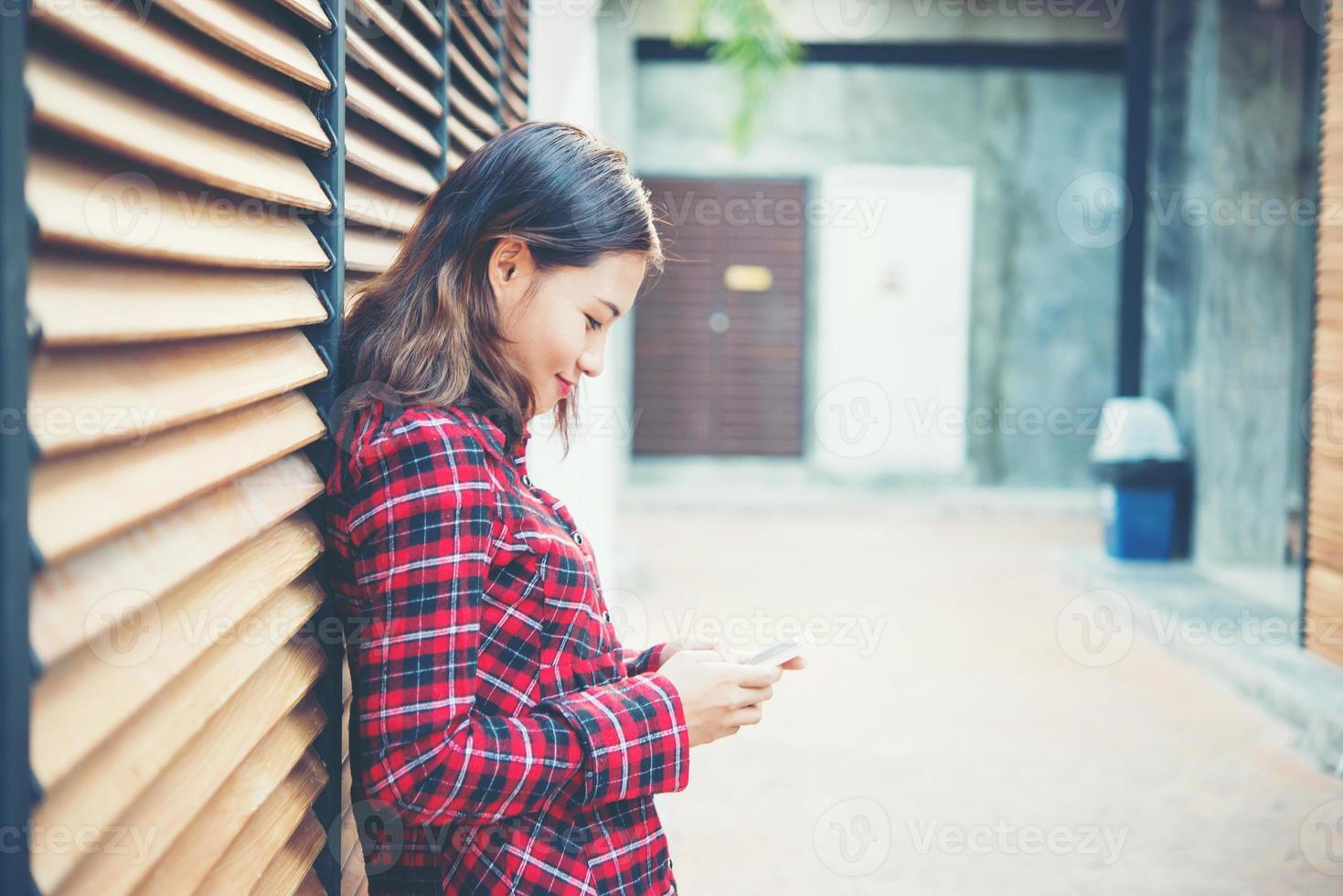 hermosa joven hipster enviando mensajes de texto en el teléfono inteligente foto