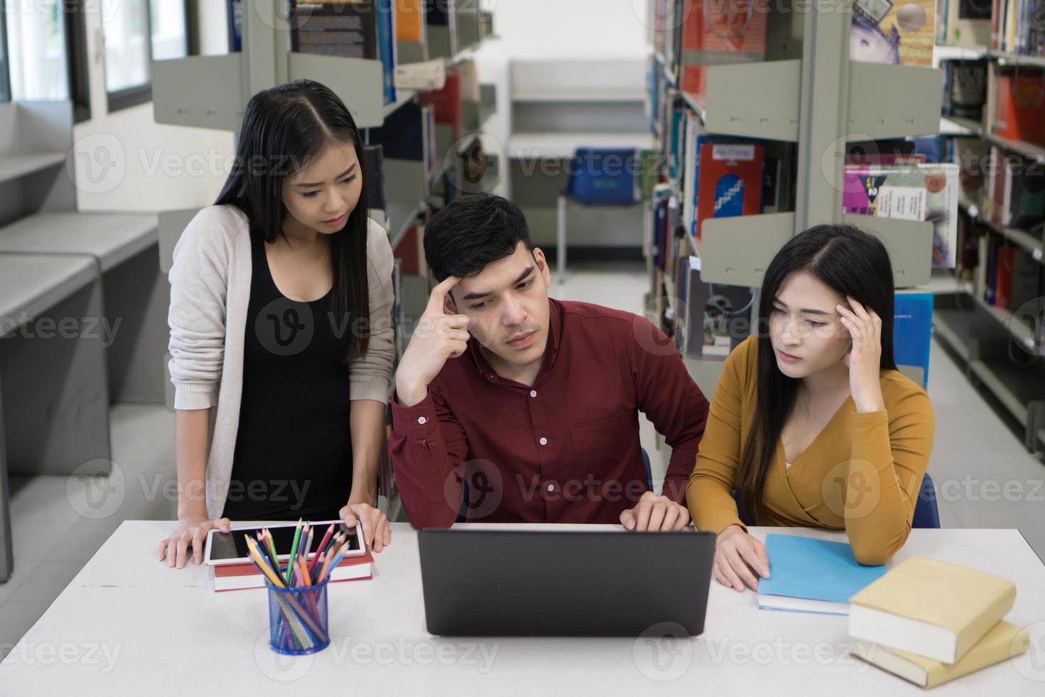 Group of college students studying in the school library photo