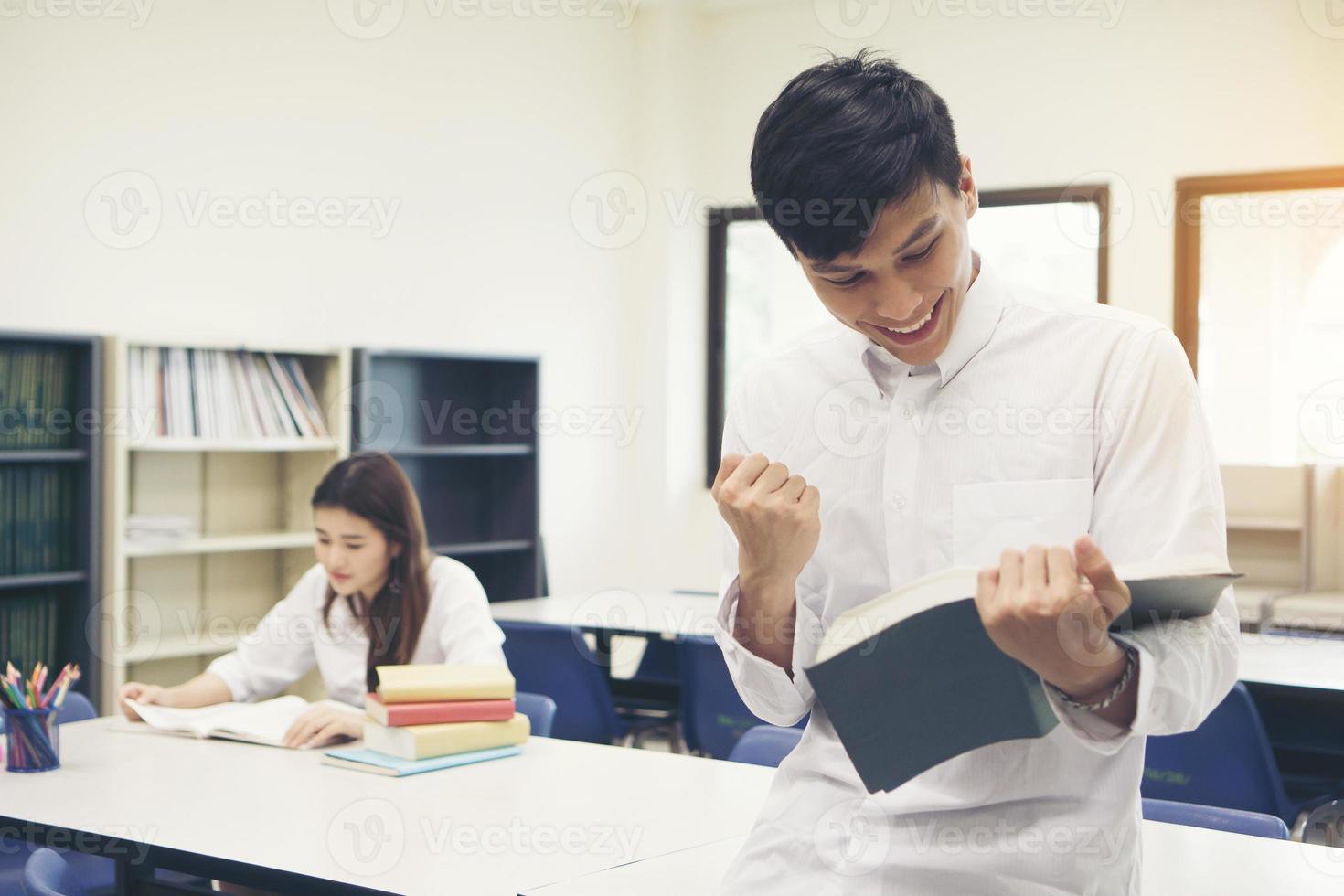 jóvenes estudiantes asiáticos en la biblioteca leyendo un libro foto