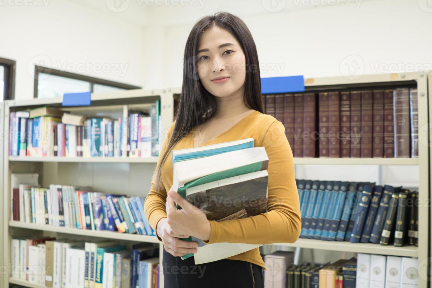 Joven estudiante bastante asiático sonriendo a la cámara foto