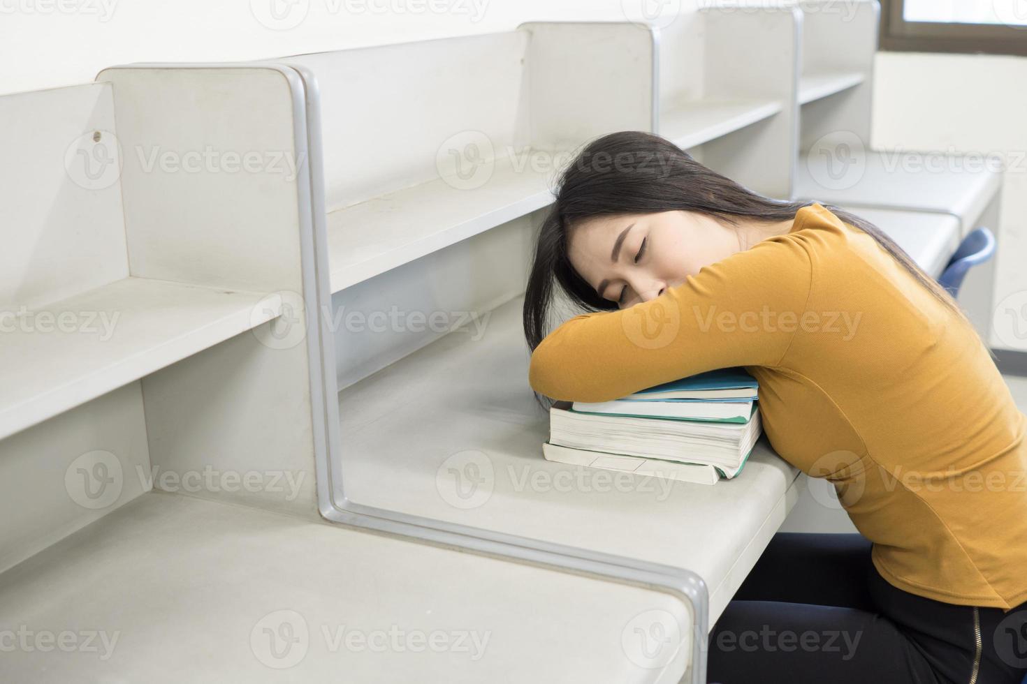 joven estudiante durmiendo en la biblioteca foto