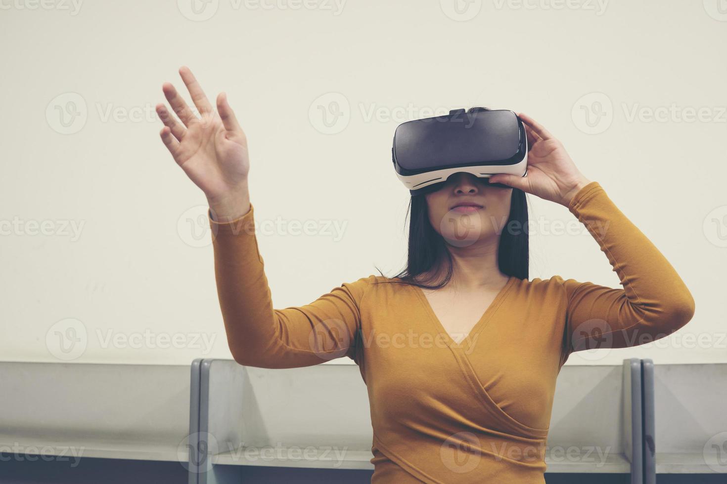 Portrait of young Asian woman wearing virtual reality goggles photo