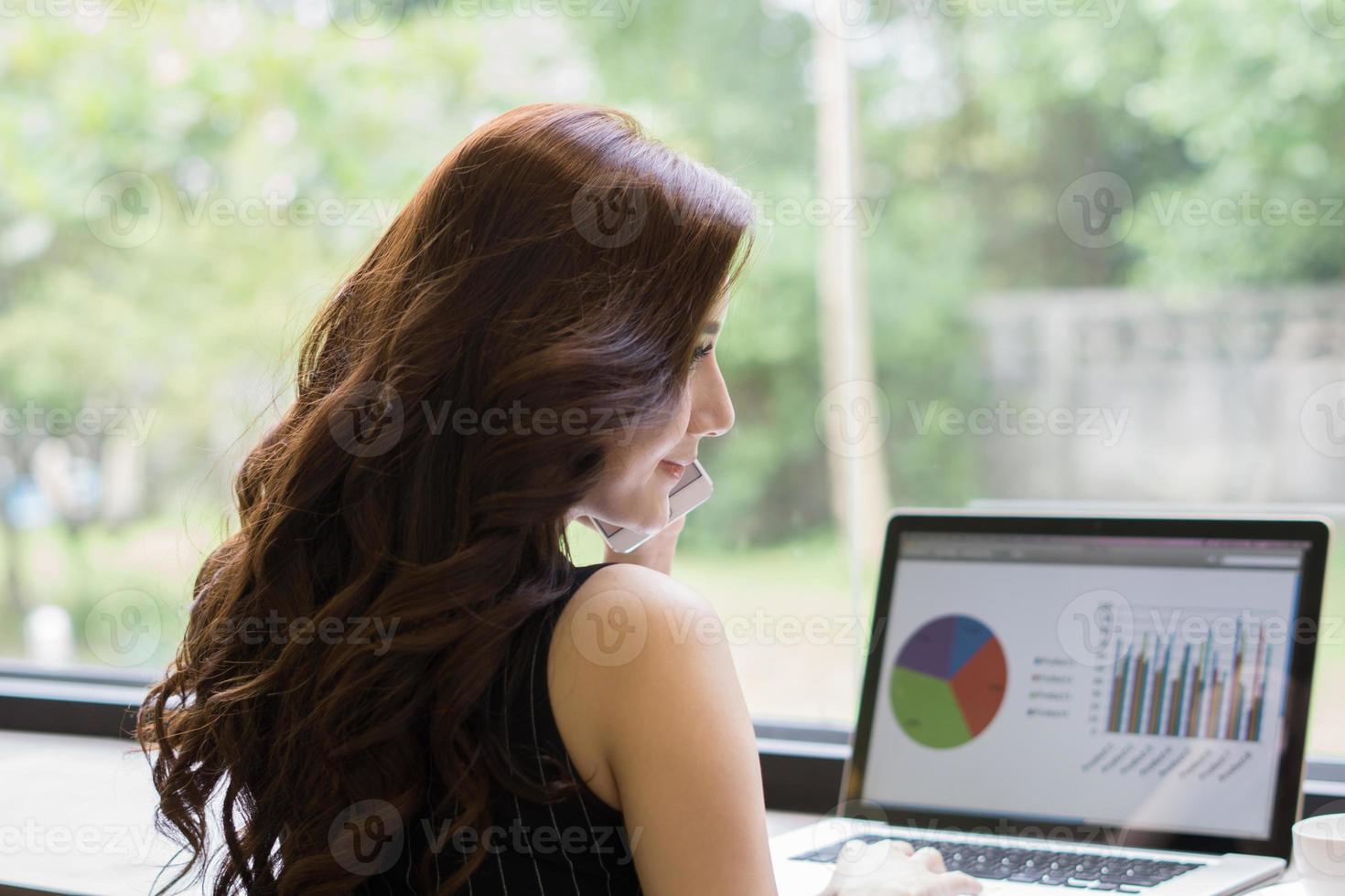 Young business woman working on laptop at office photo