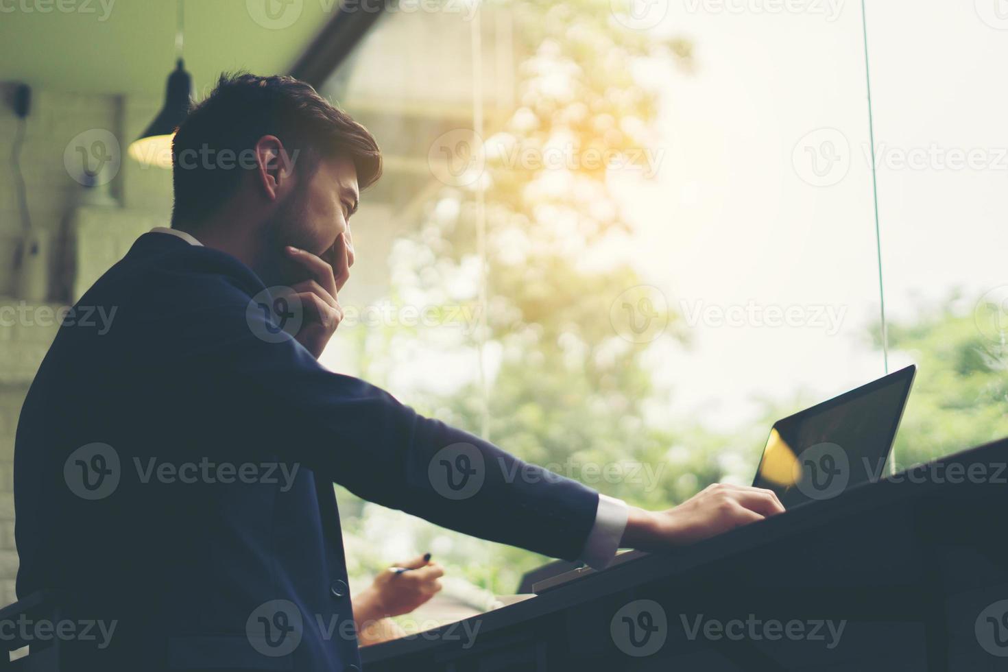 Young businessman working on laptop at office photo