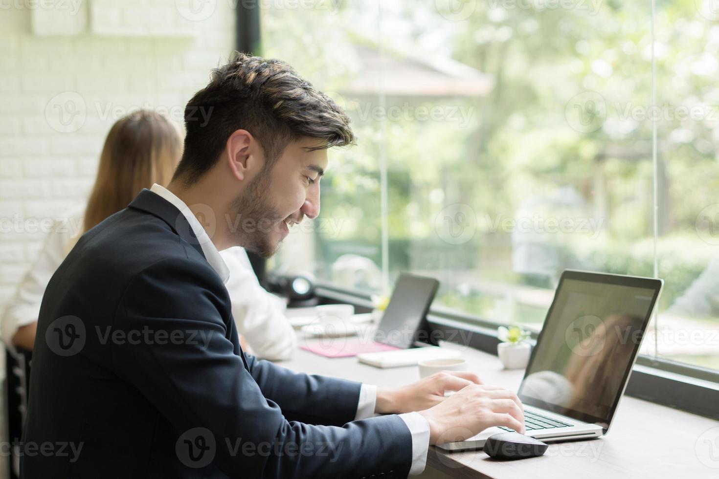 Young businessman working on laptop at office photo