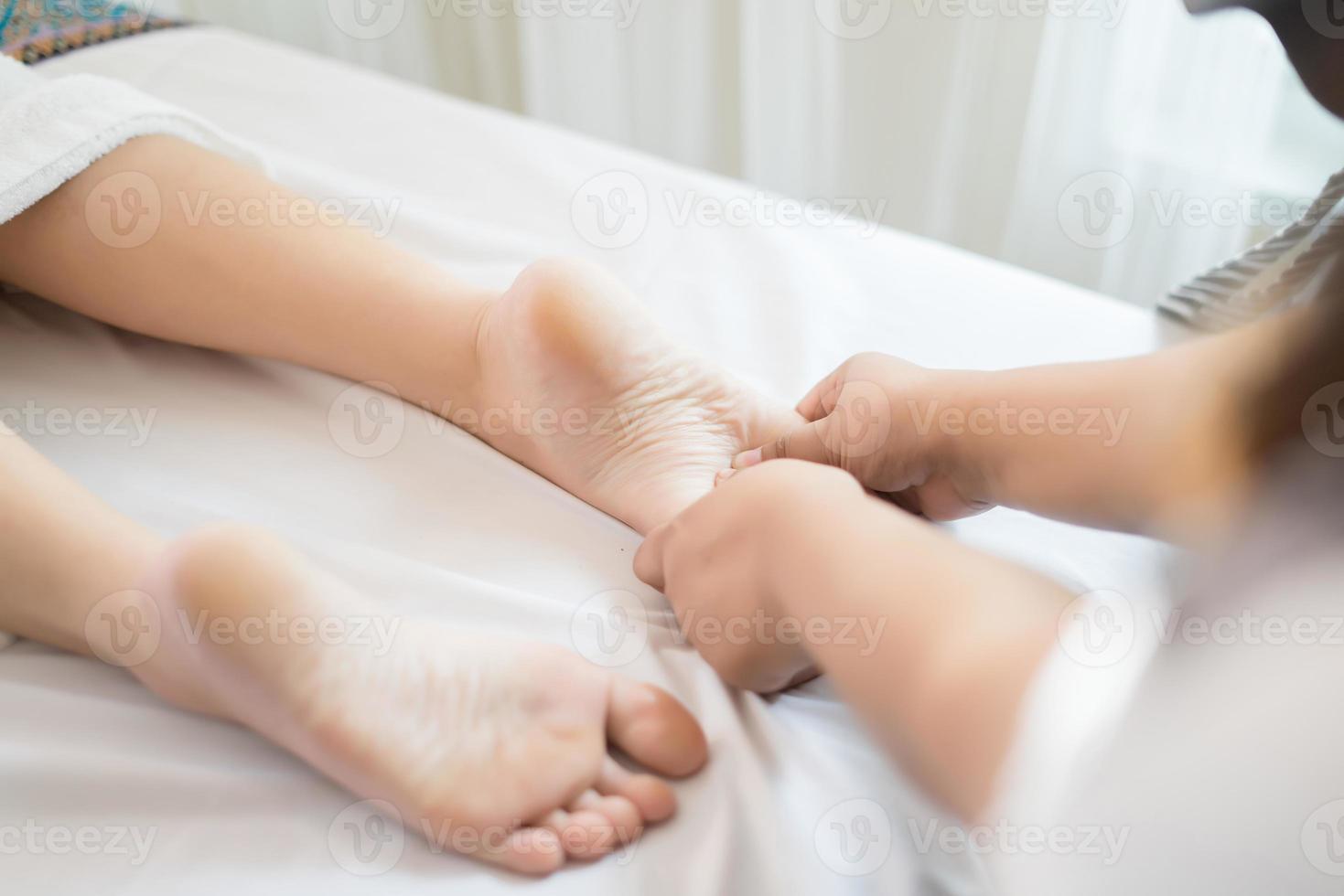 mujer recibiendo un masaje de pies en el salón spa foto