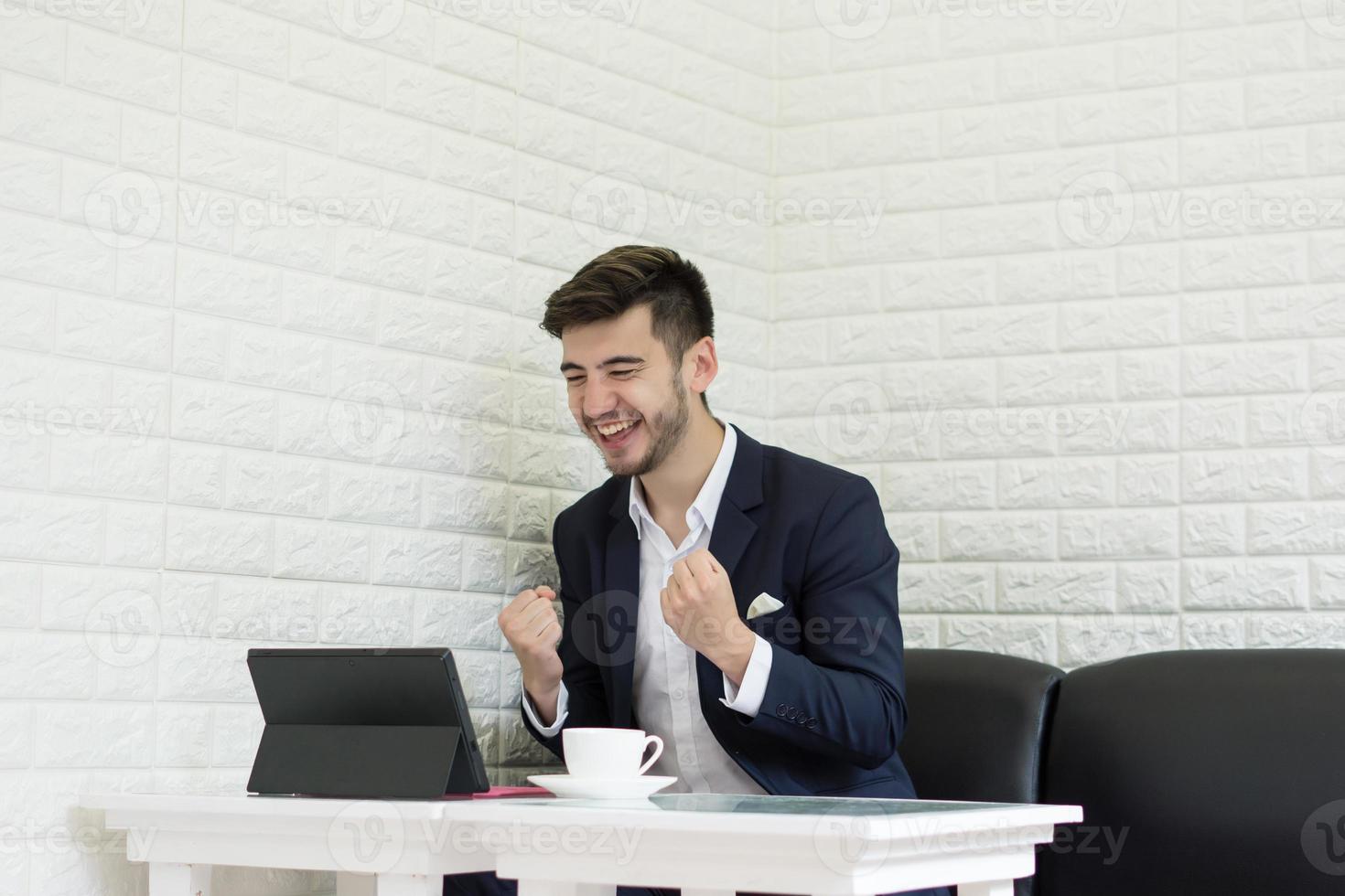 Young businessman having a coffee break working on laptop photo