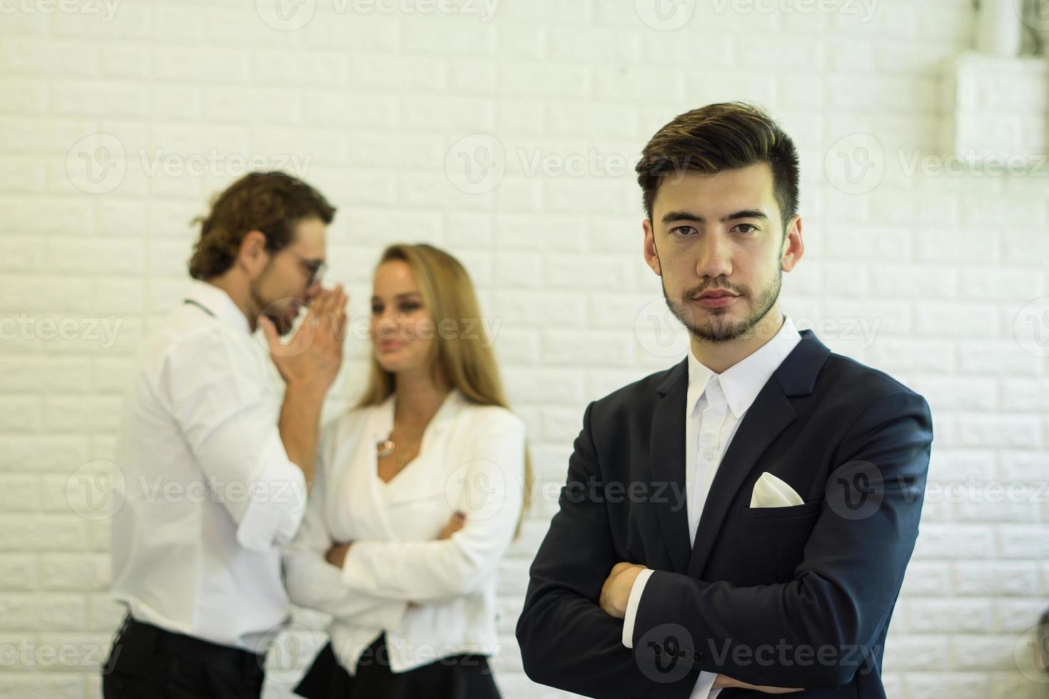 Confident businessman with team behind photo