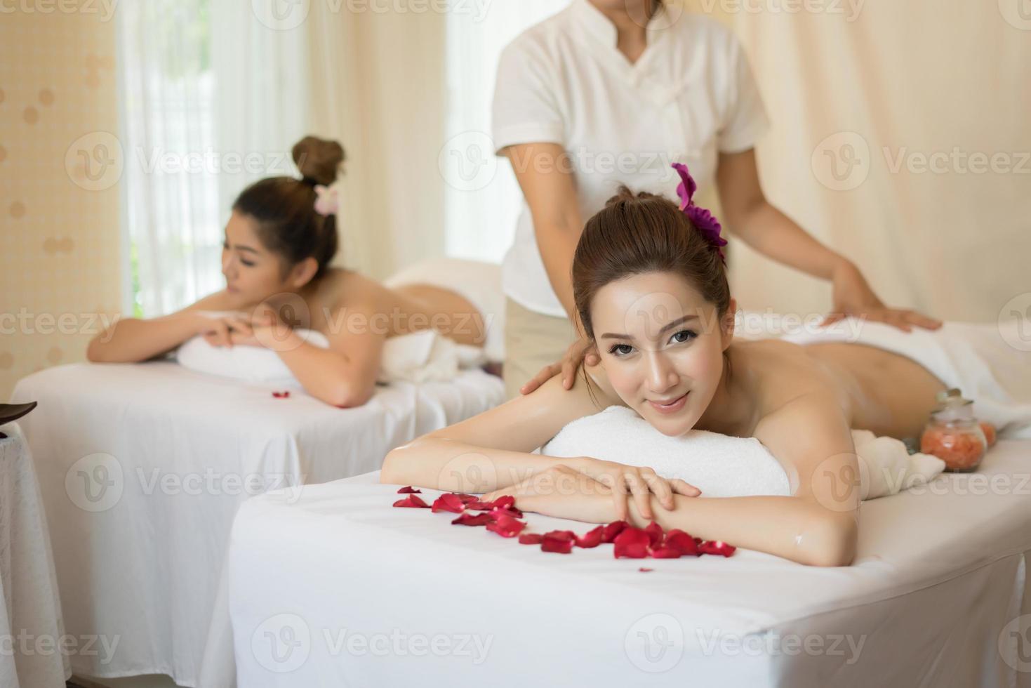 Mujer hermosa joven con masaje saludable en un salón de spa foto