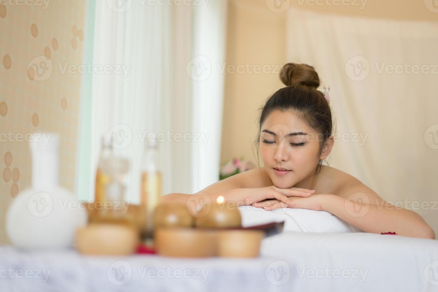 Mujer hermosa joven con masaje saludable en un salón de spa foto