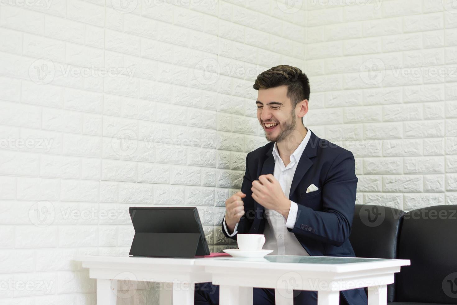 Successful young businessman working on laptop at office photo