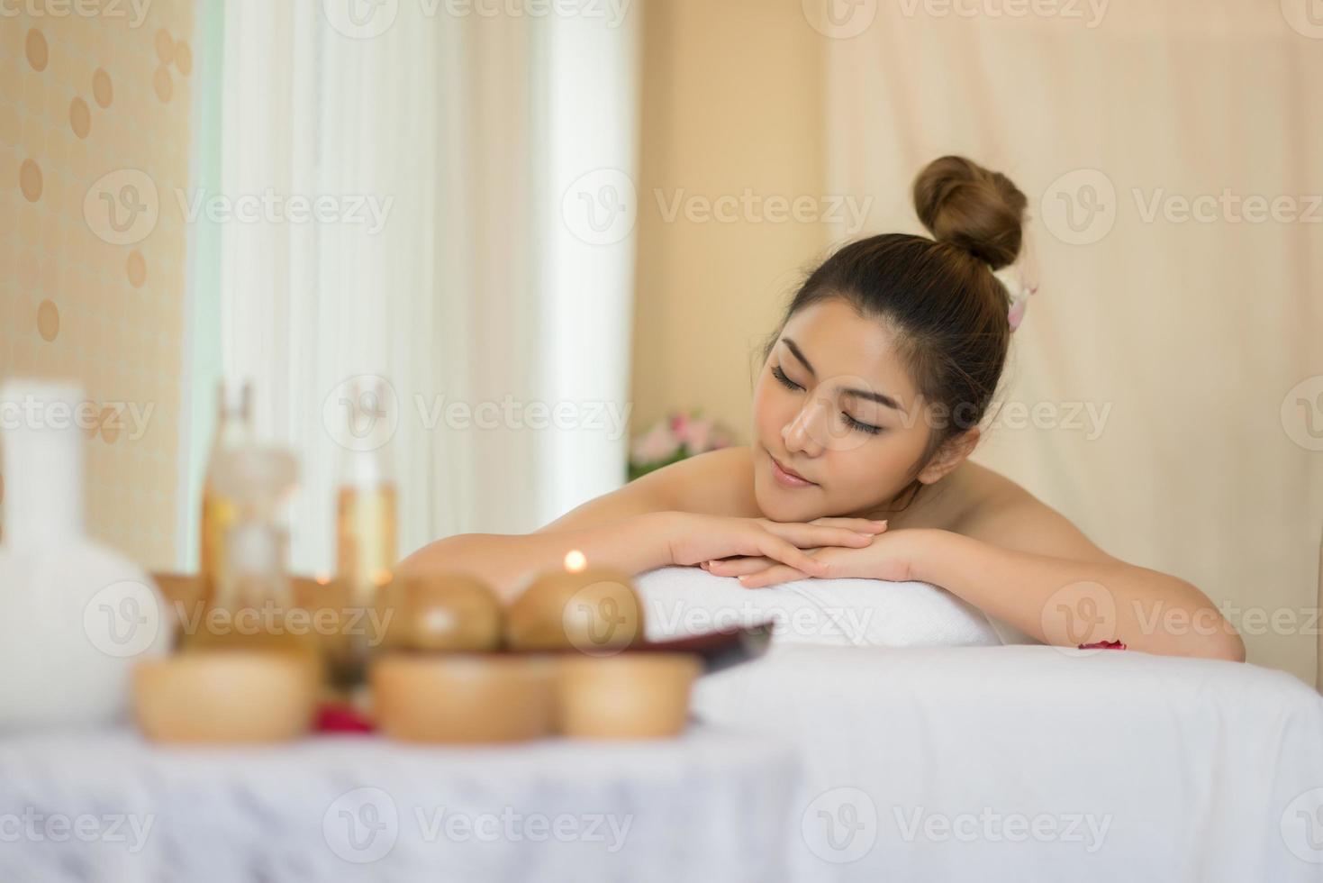 Mujer hermosa joven con masaje saludable en un salón de spa foto